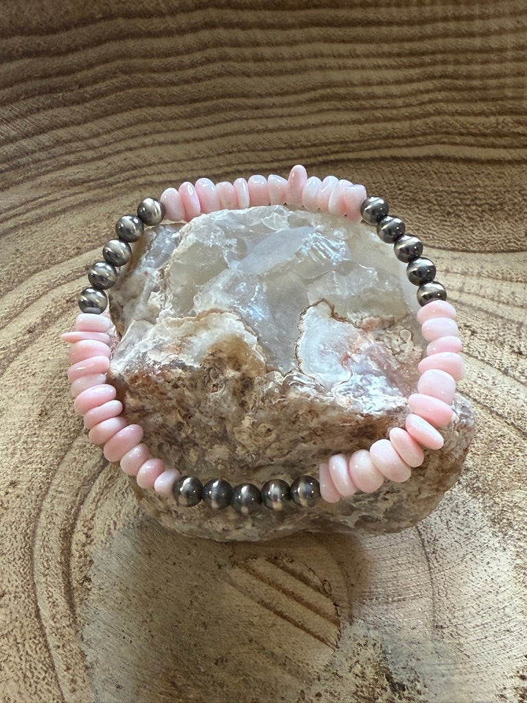 Pink beaded bracelet on a rock with a textured brown background