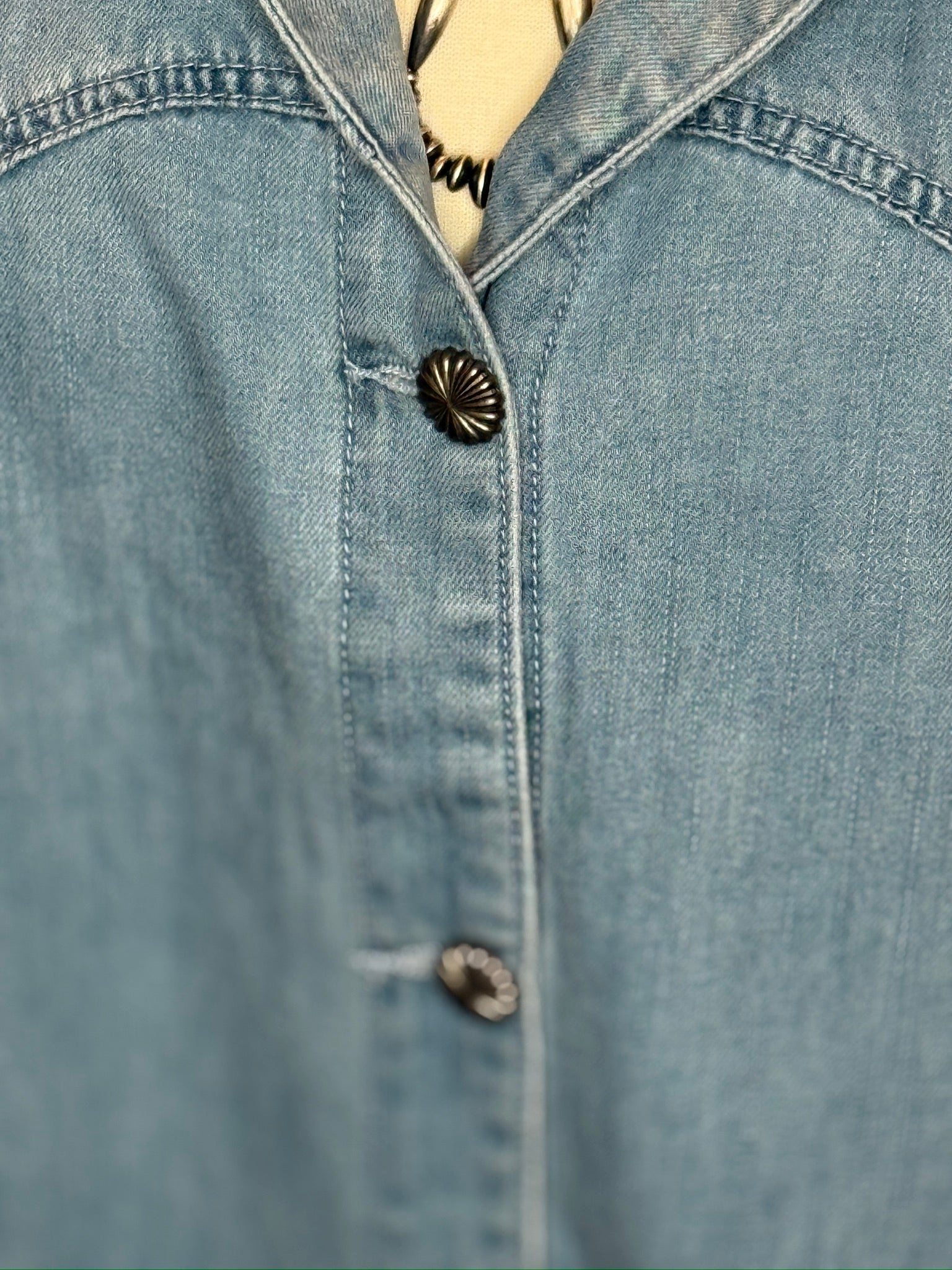Close-up of a denim shirt with buttons.