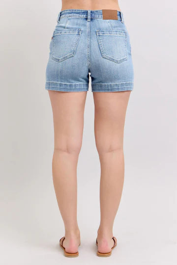 Back view of light blue denim shorts on a plain background.