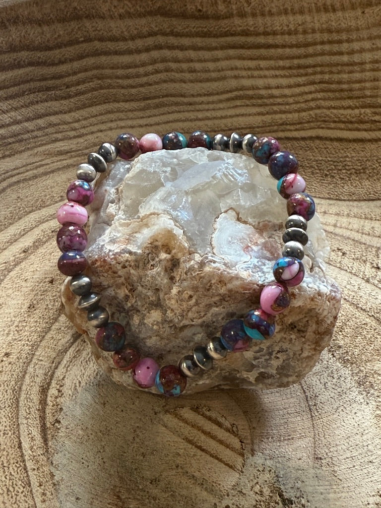 Multicolored beaded bracelet on a crystal with a natural stone background