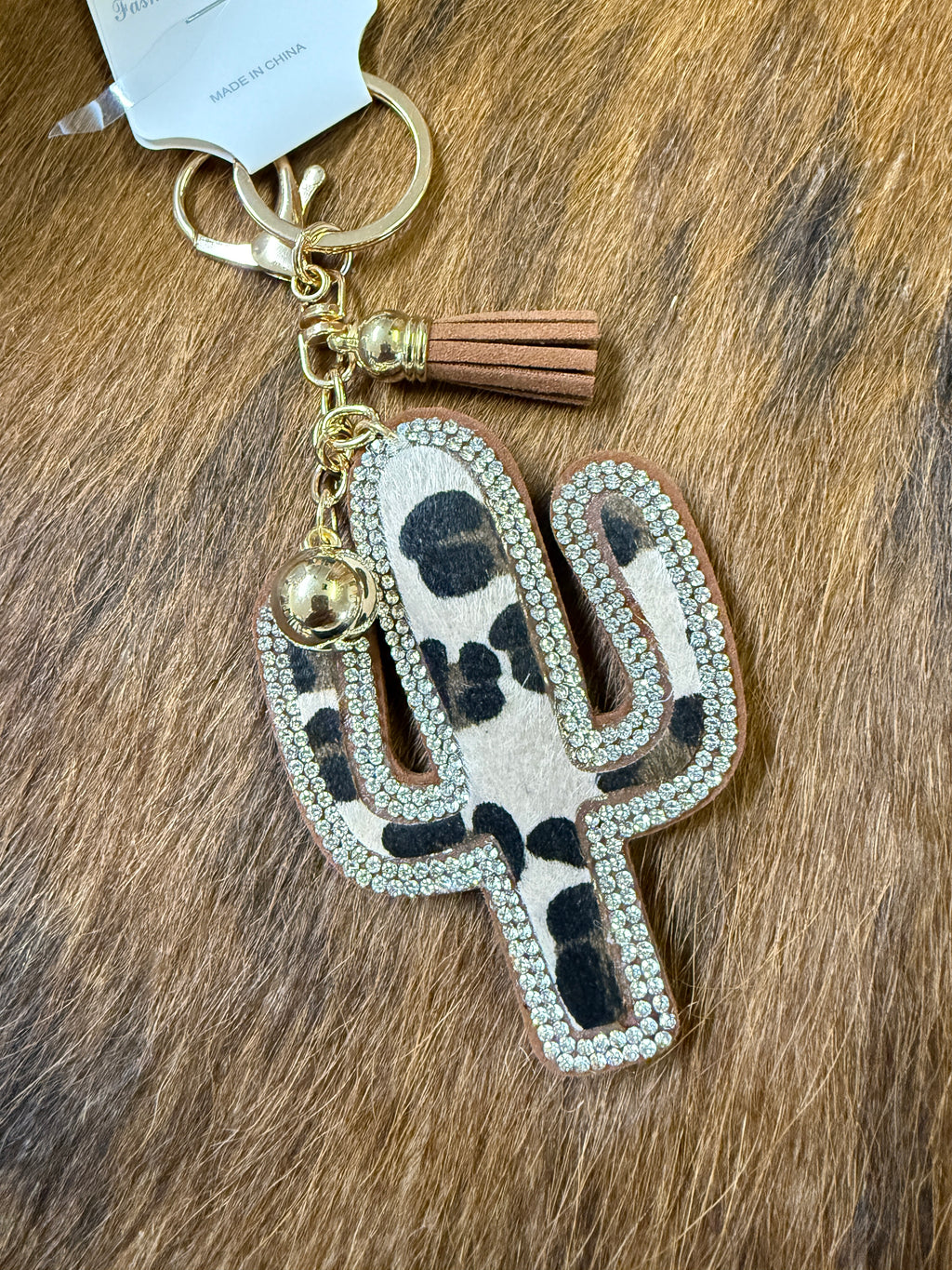 Leopard print keychain with tassel on a wooden surface