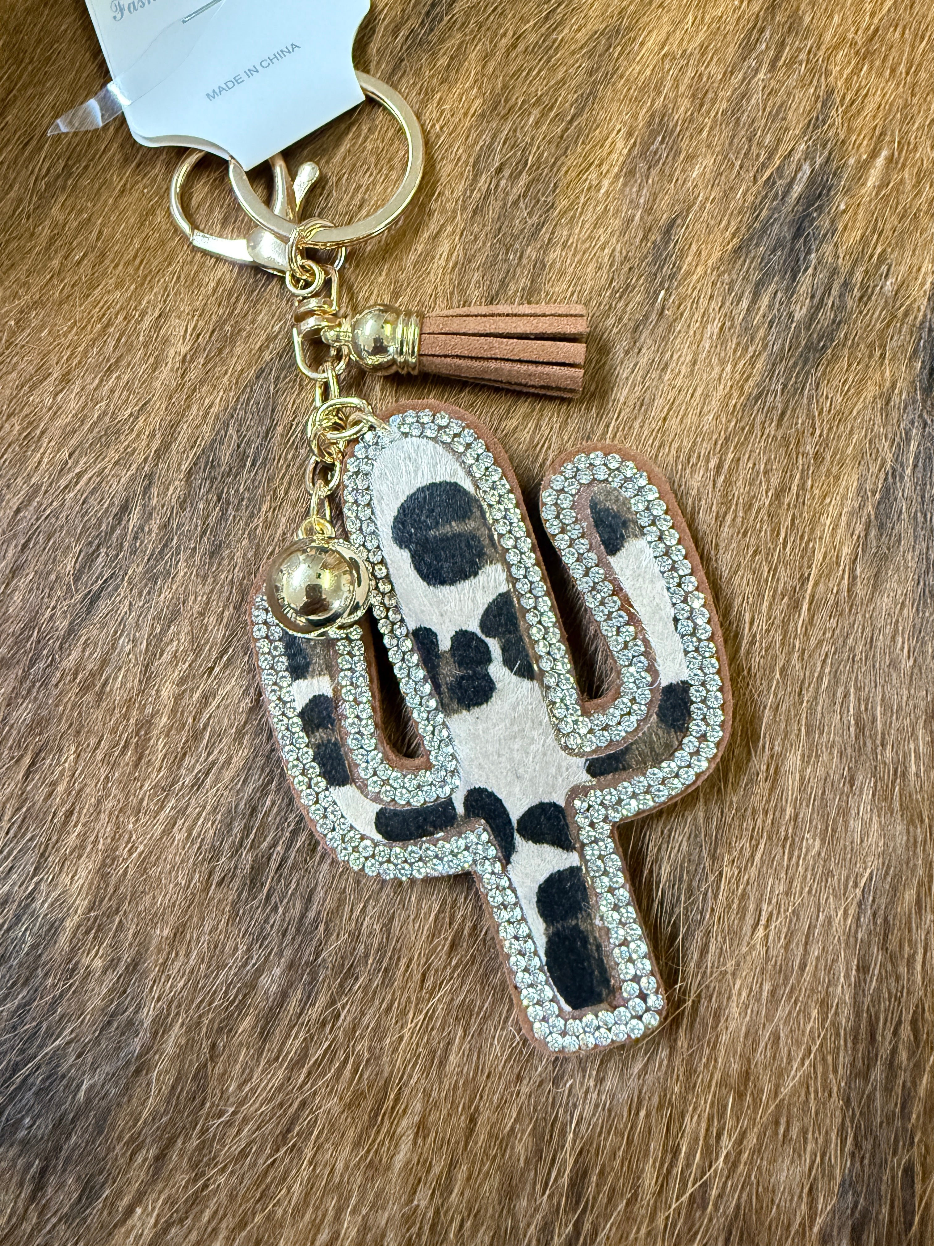 Leopard print keychain with tassel on a wooden surface