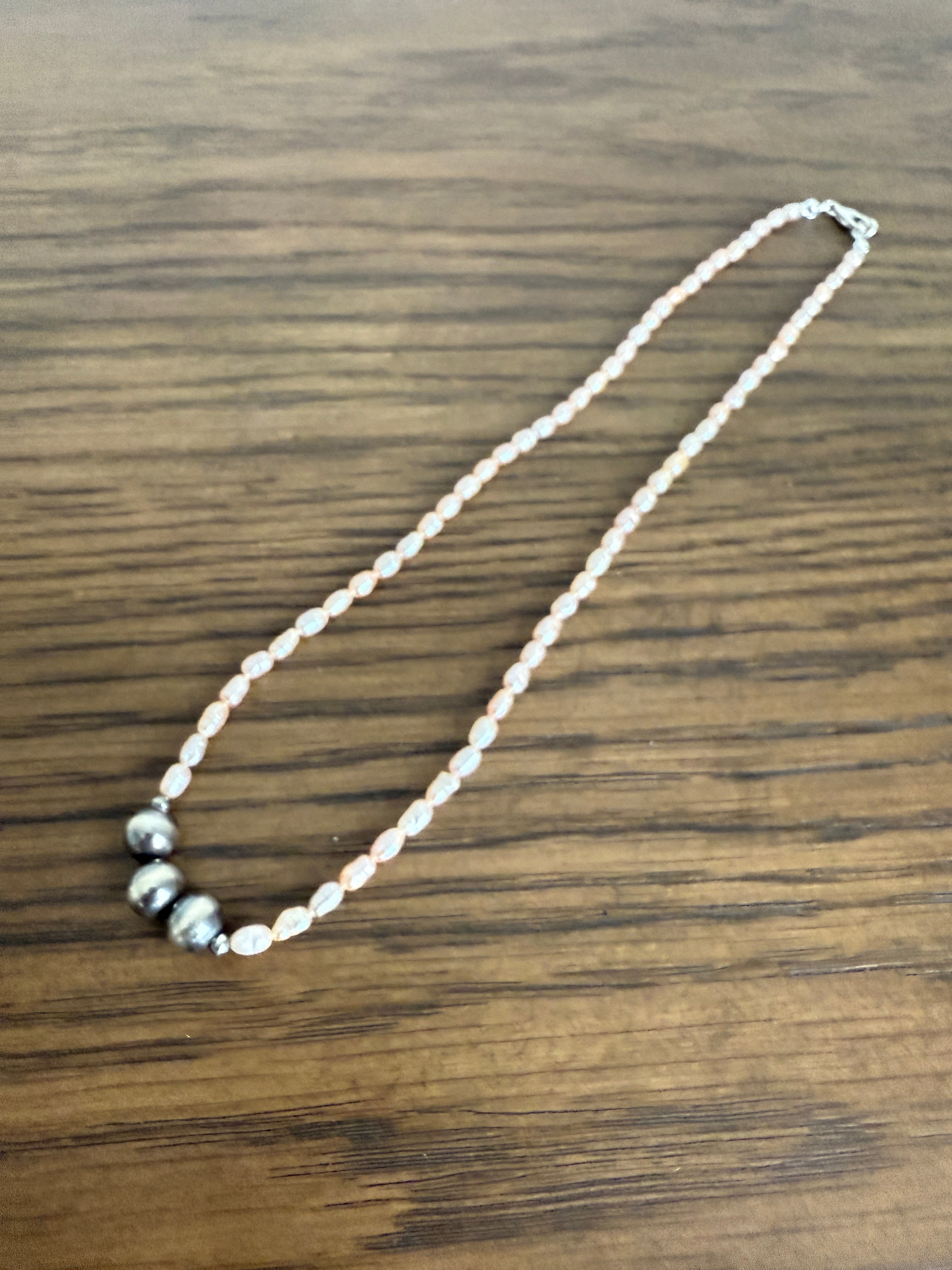 Pearl necklace with silver beads on a wooden surface