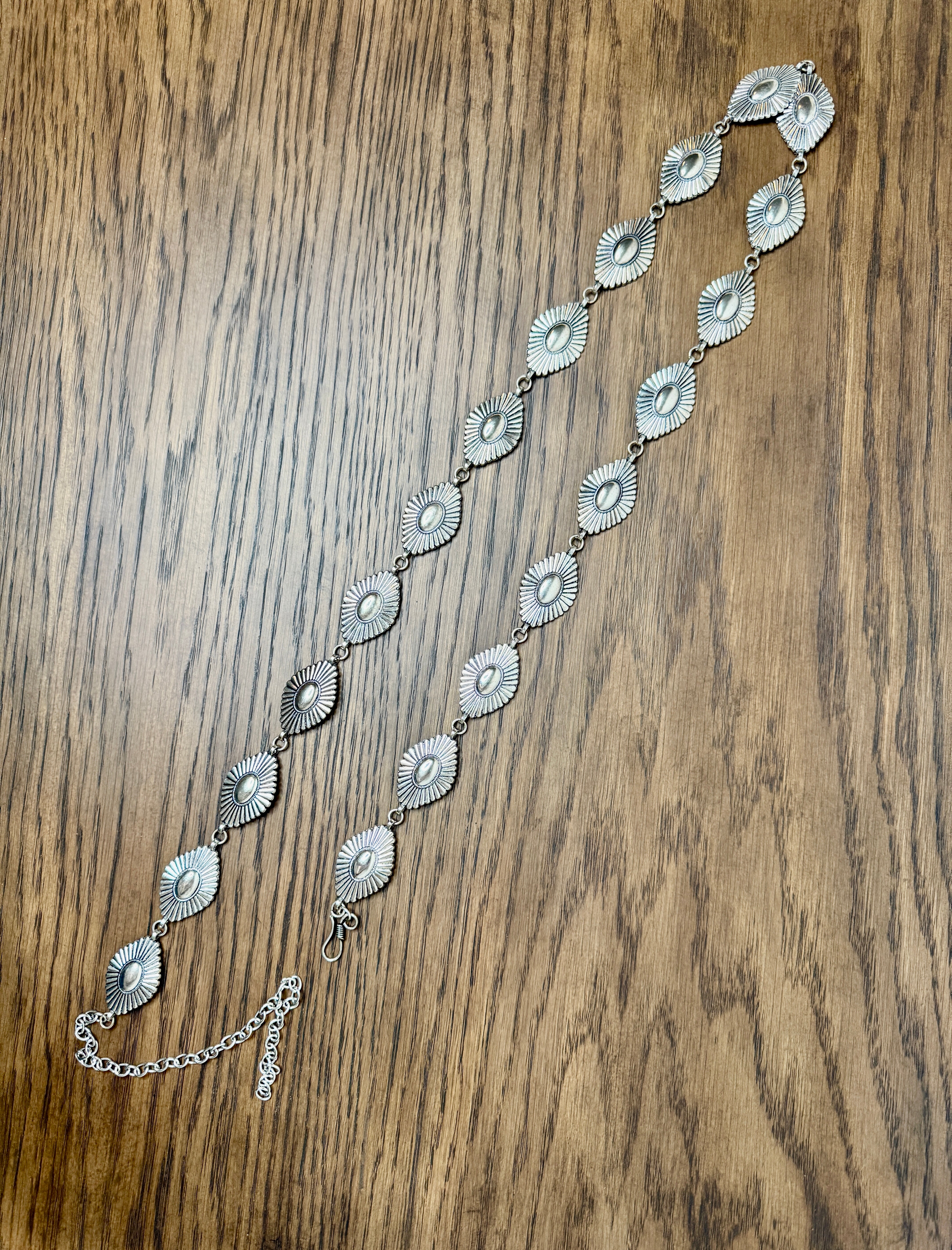 Silver chain belt on a wooden surface