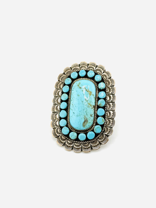Turquoise stone ring with silver decorative band on a white background
