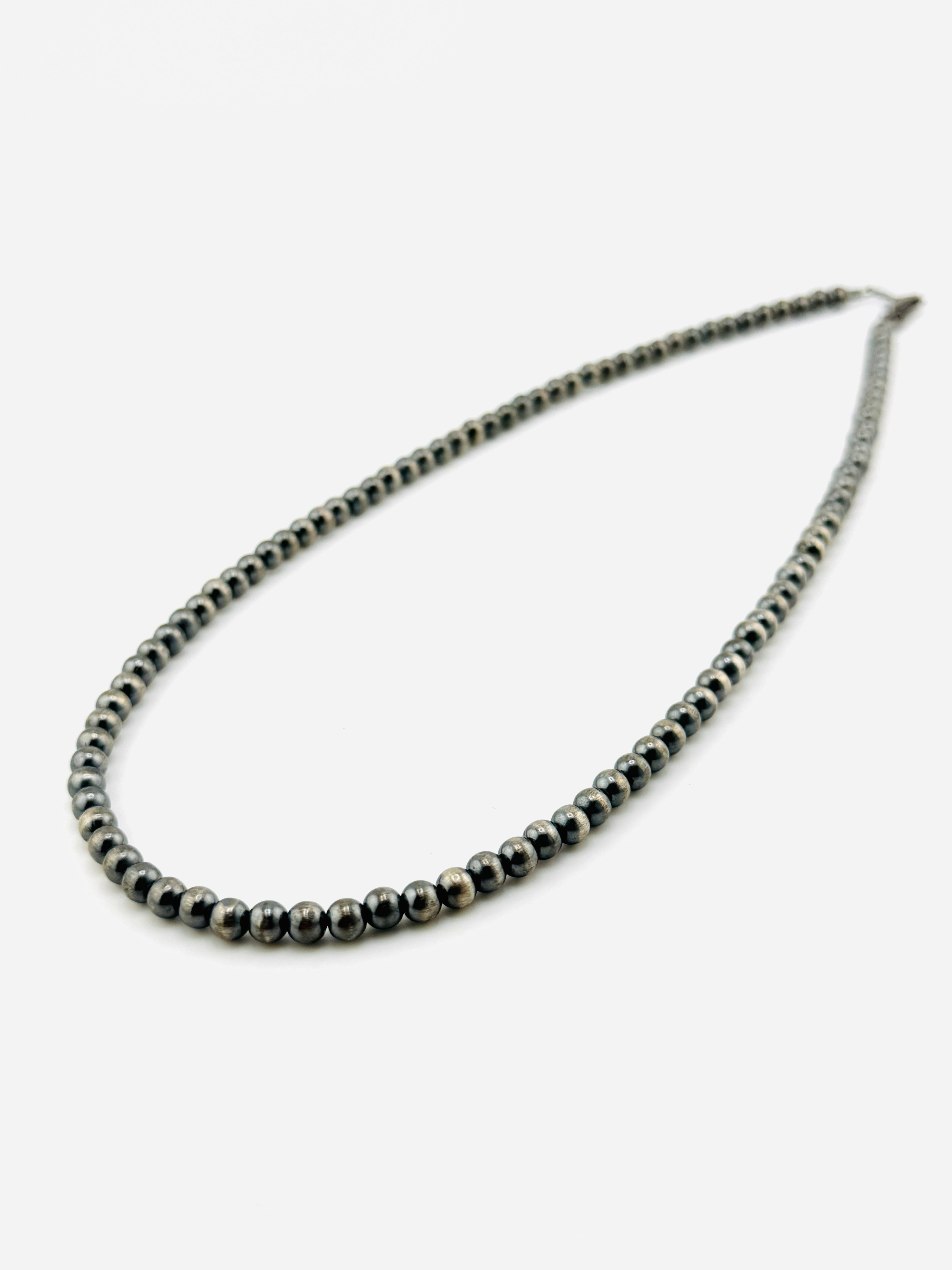 Necklace with silver beads on a white background