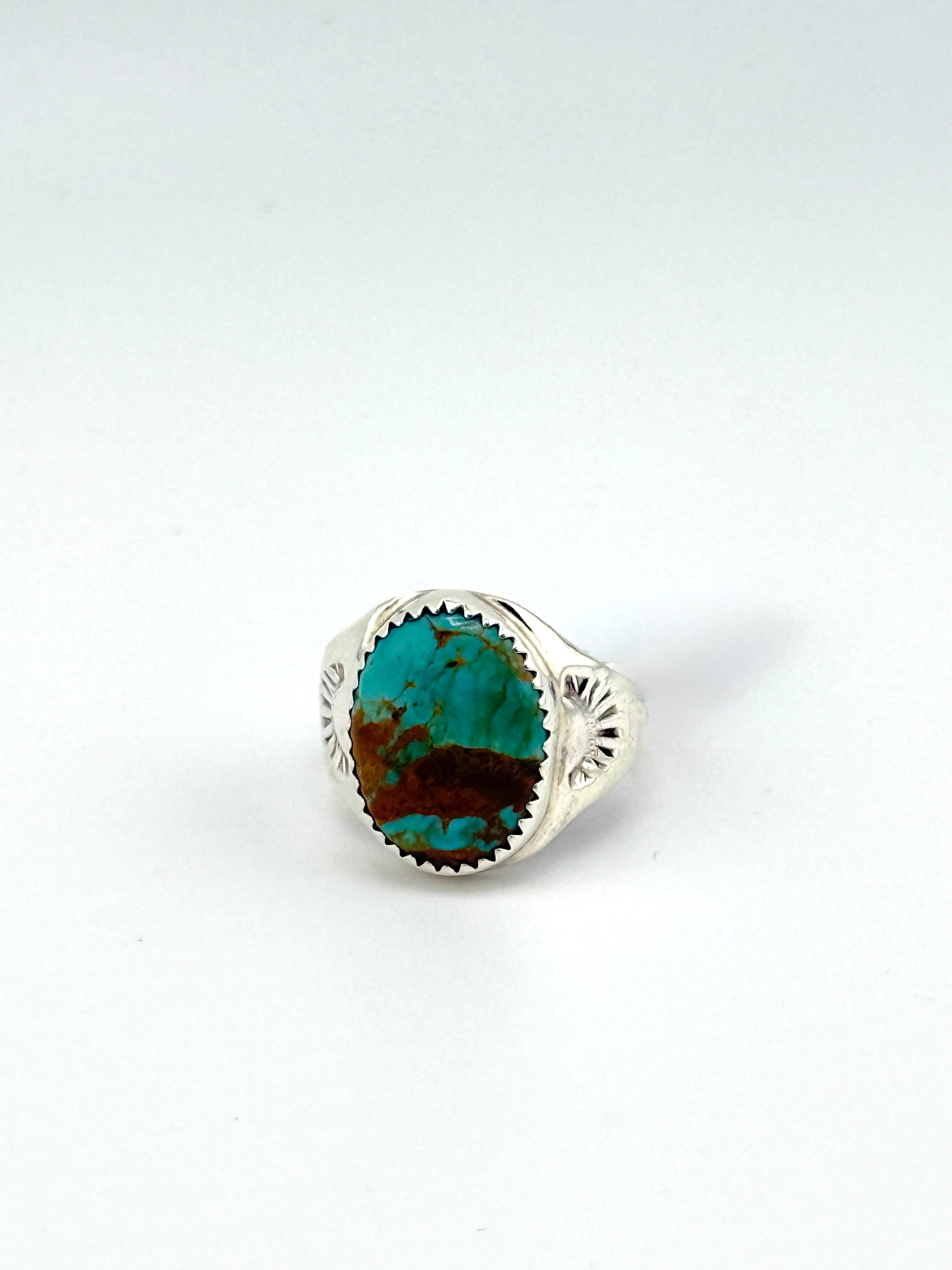 Turquoise stone in a silver setting on a white background