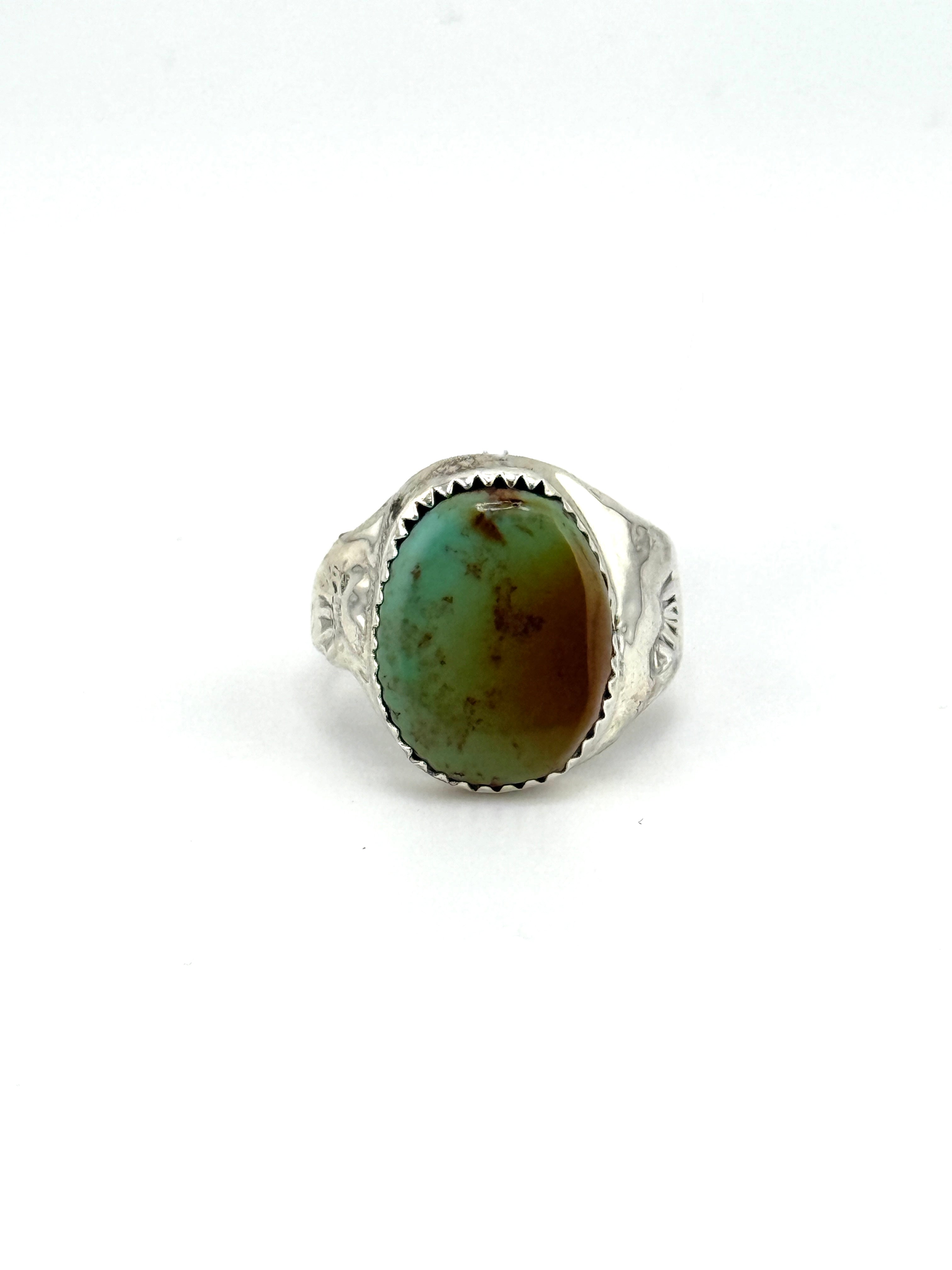 Silver ring with a green stone on a white background