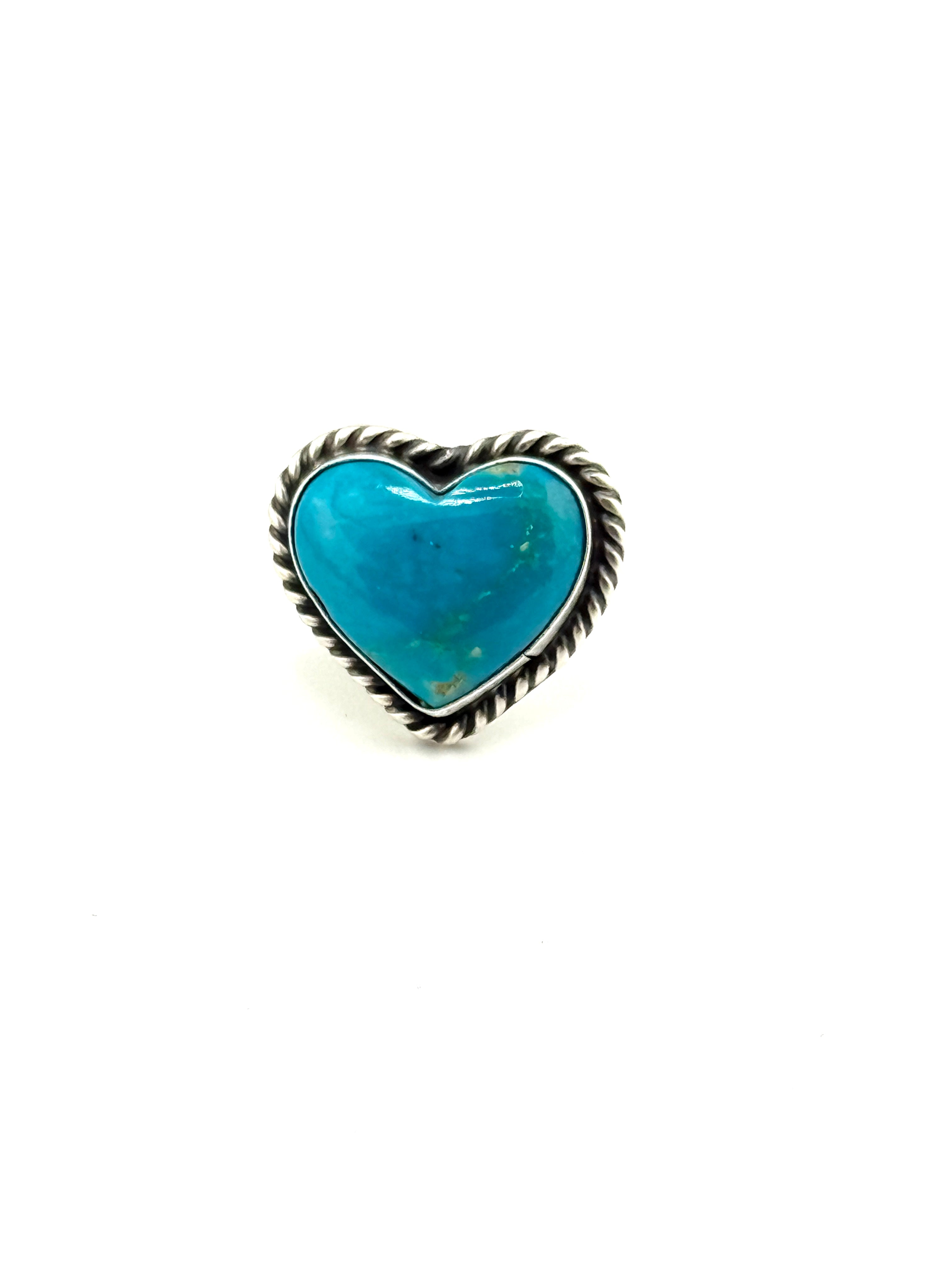 Heart-shaped turquoise stone ring with silver band on a white background