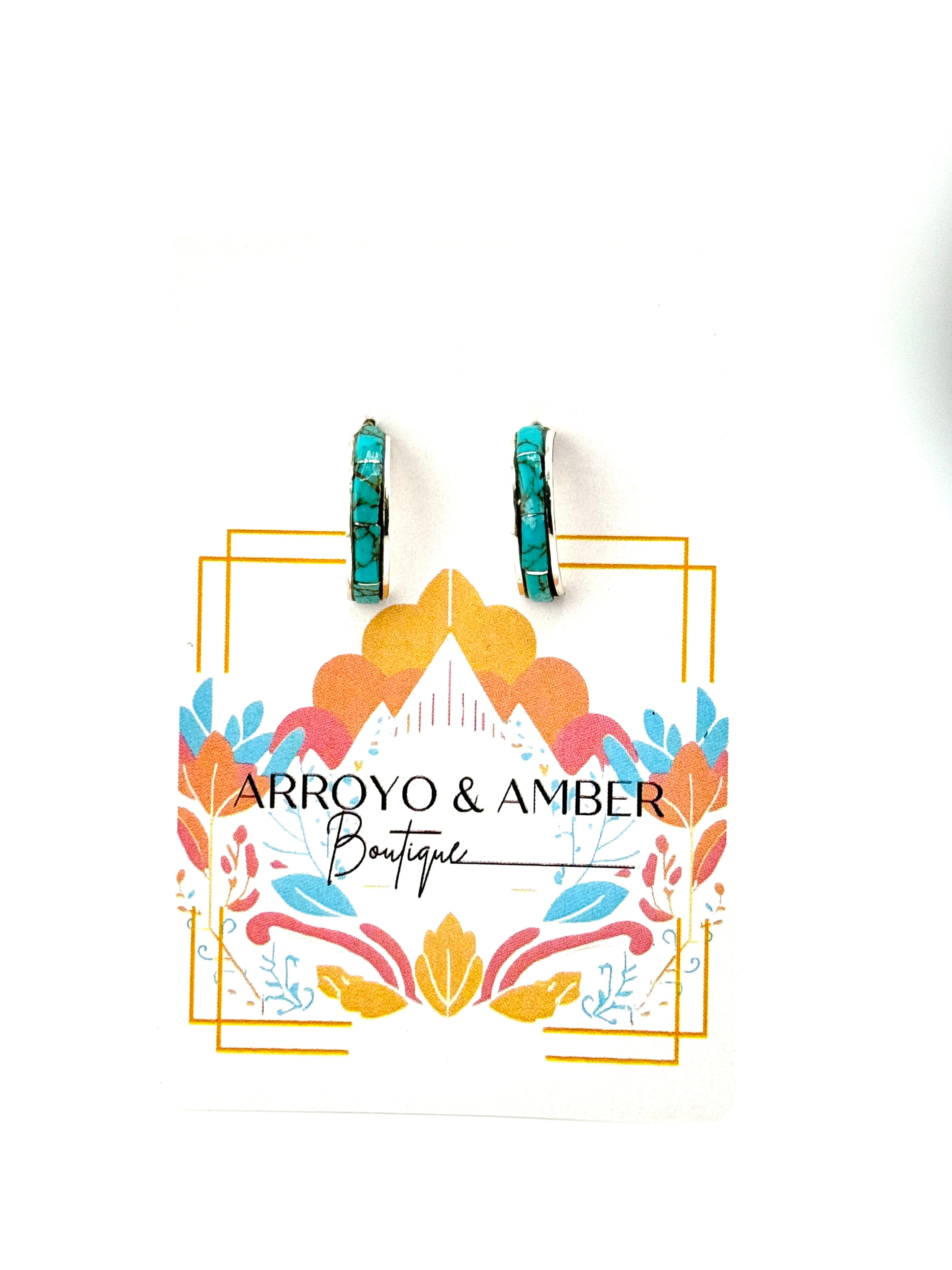 Turquoise earrings on a branded card for Arroyo & Amber Boutique