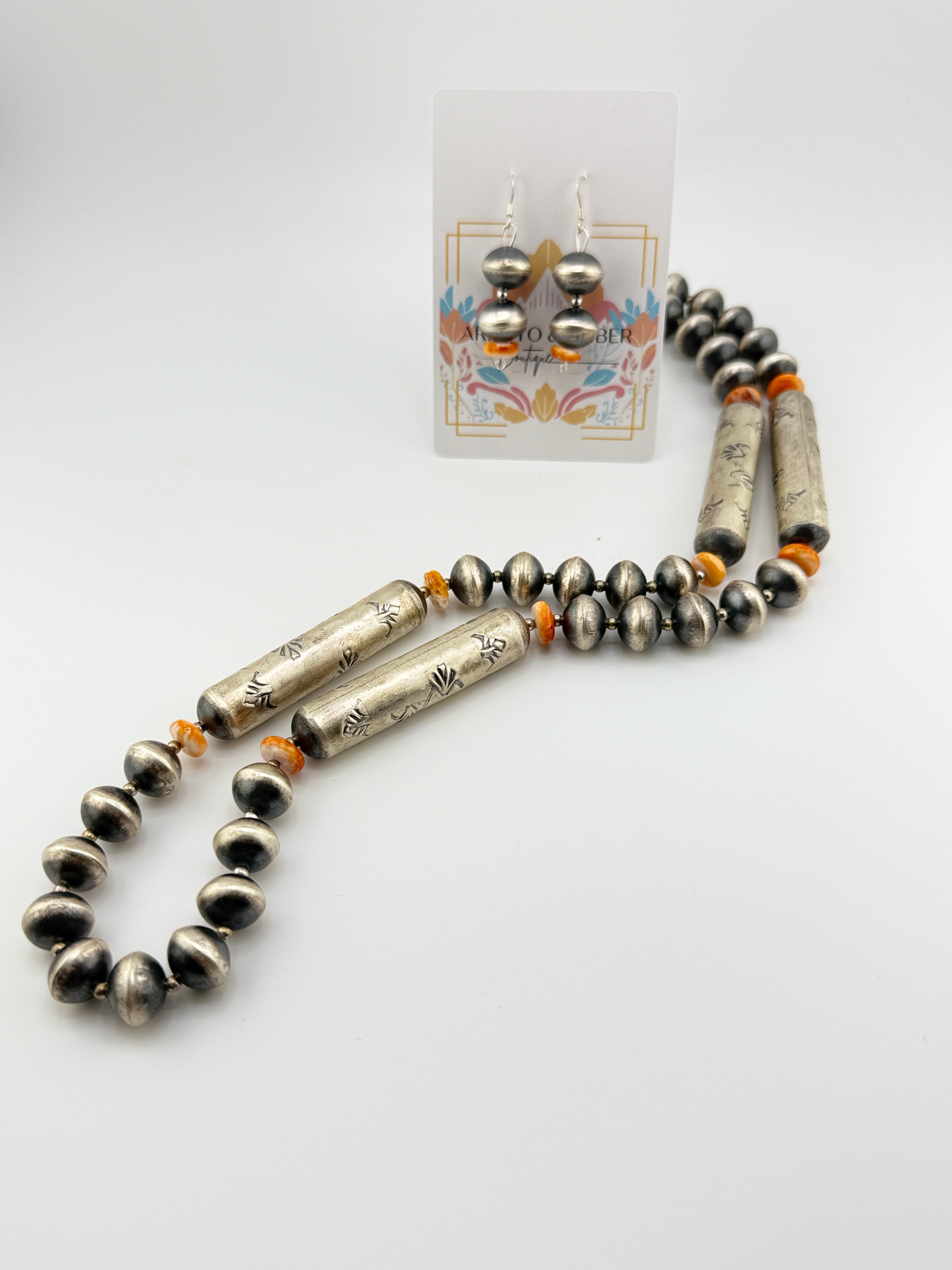 Beaded necklace with silver and black beads on a white background