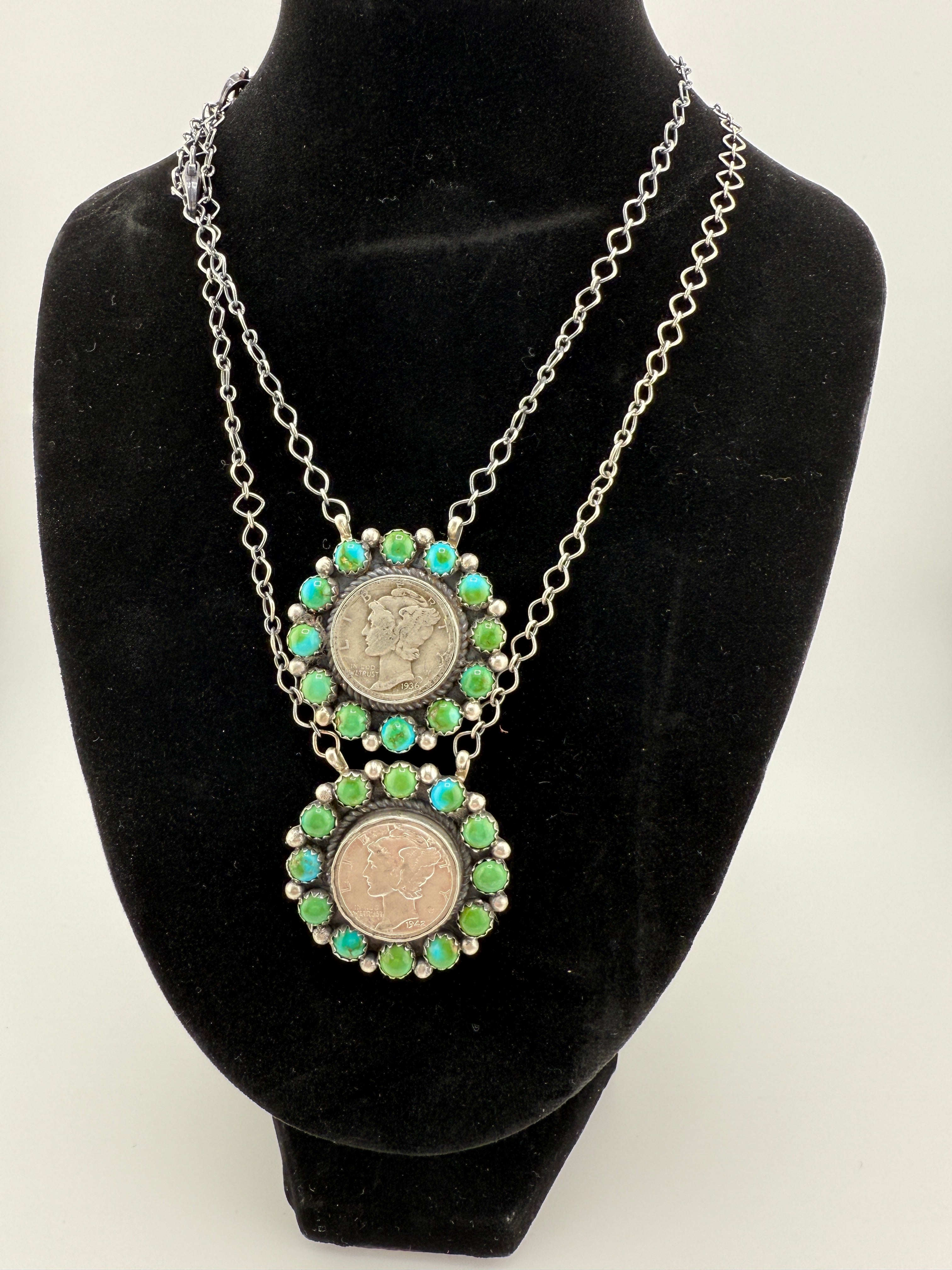 Necklace with coin and green stone design on a black velvet stand