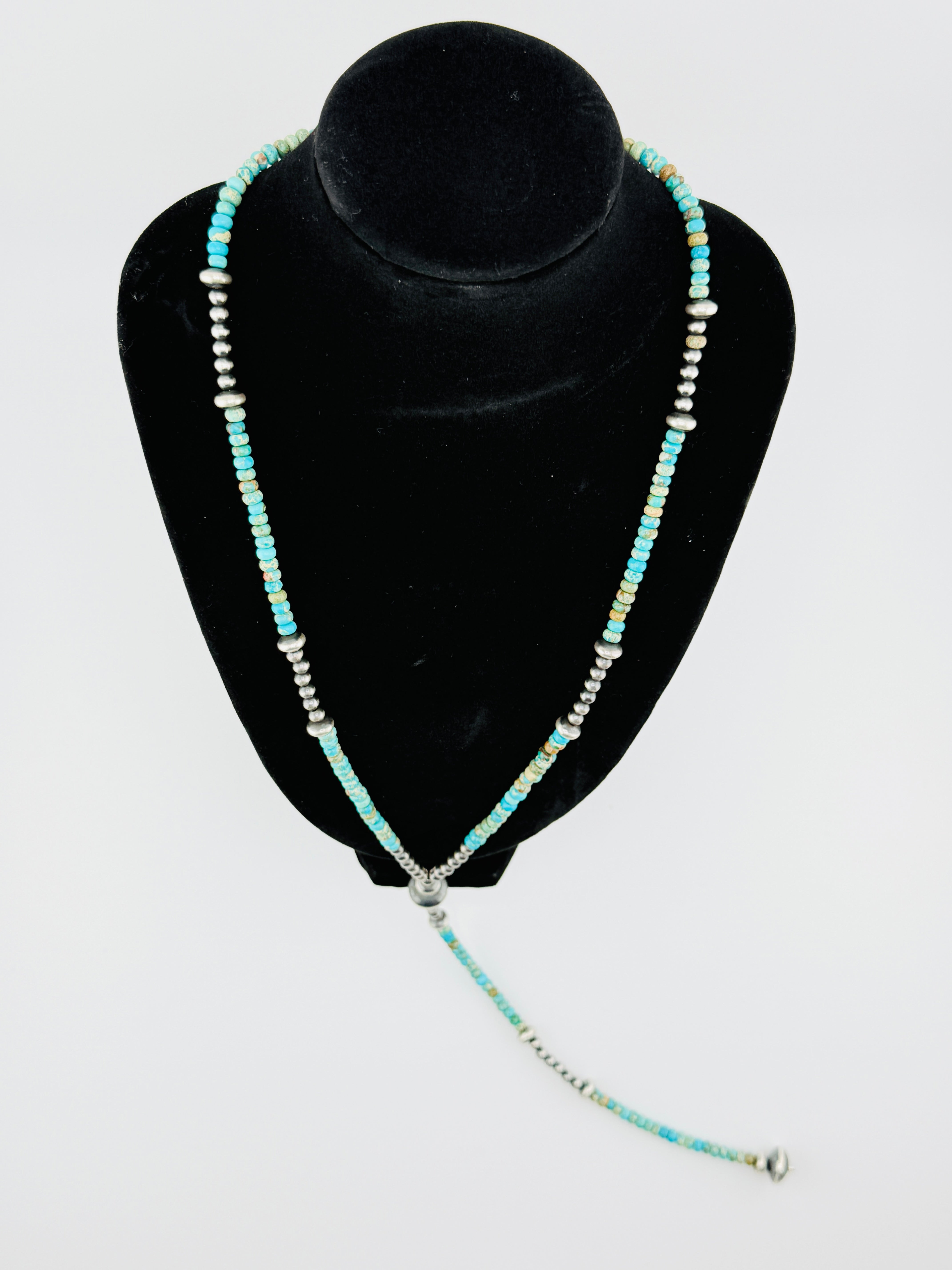Beaded necklace on a black velvet stand against a white background