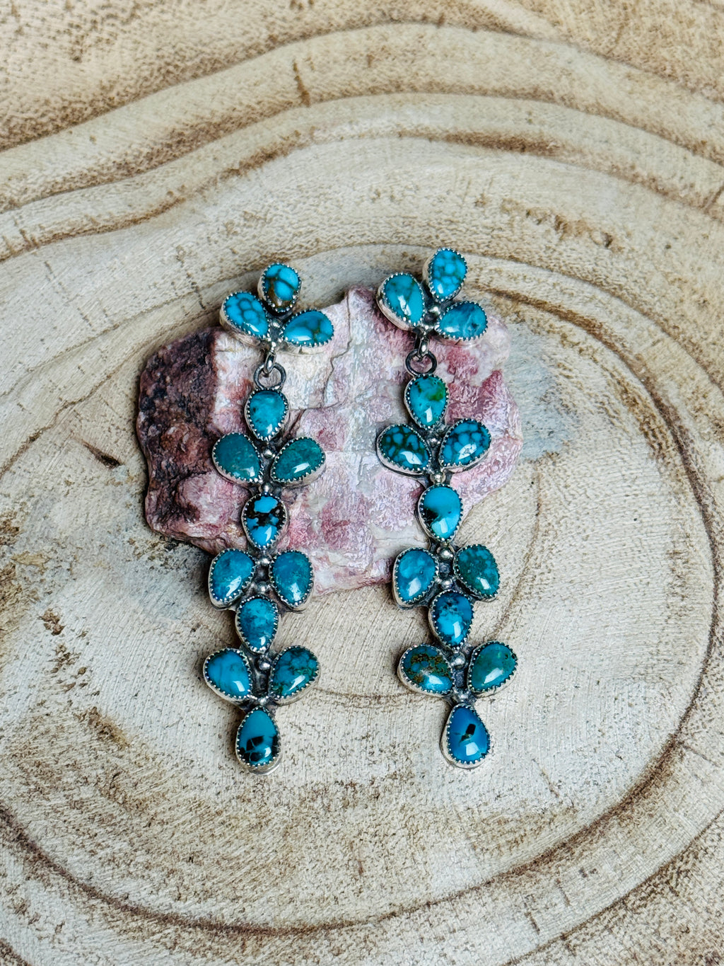 Turquoise earrings on a wooden surface