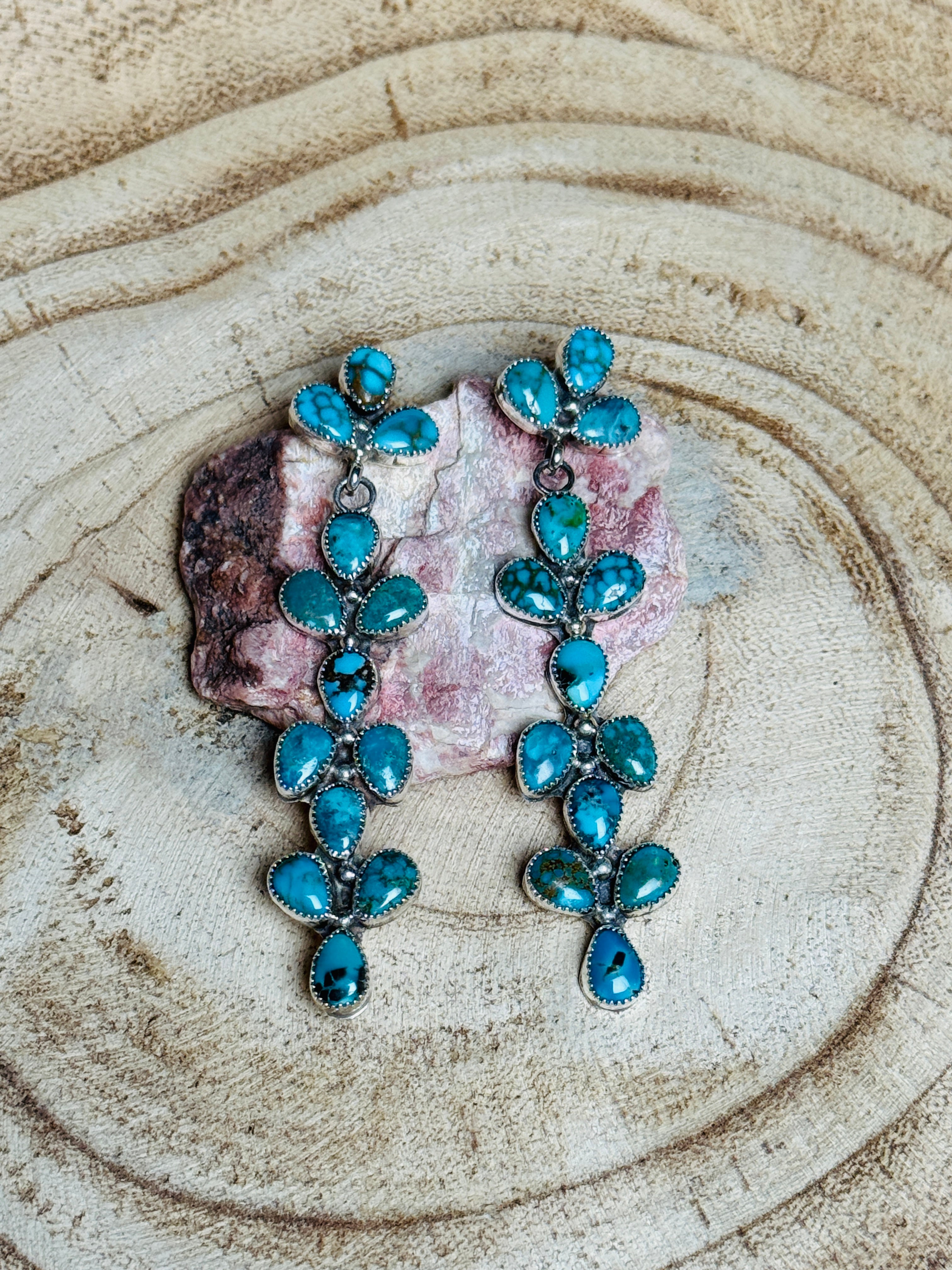 Turquoise earrings on a wooden surface