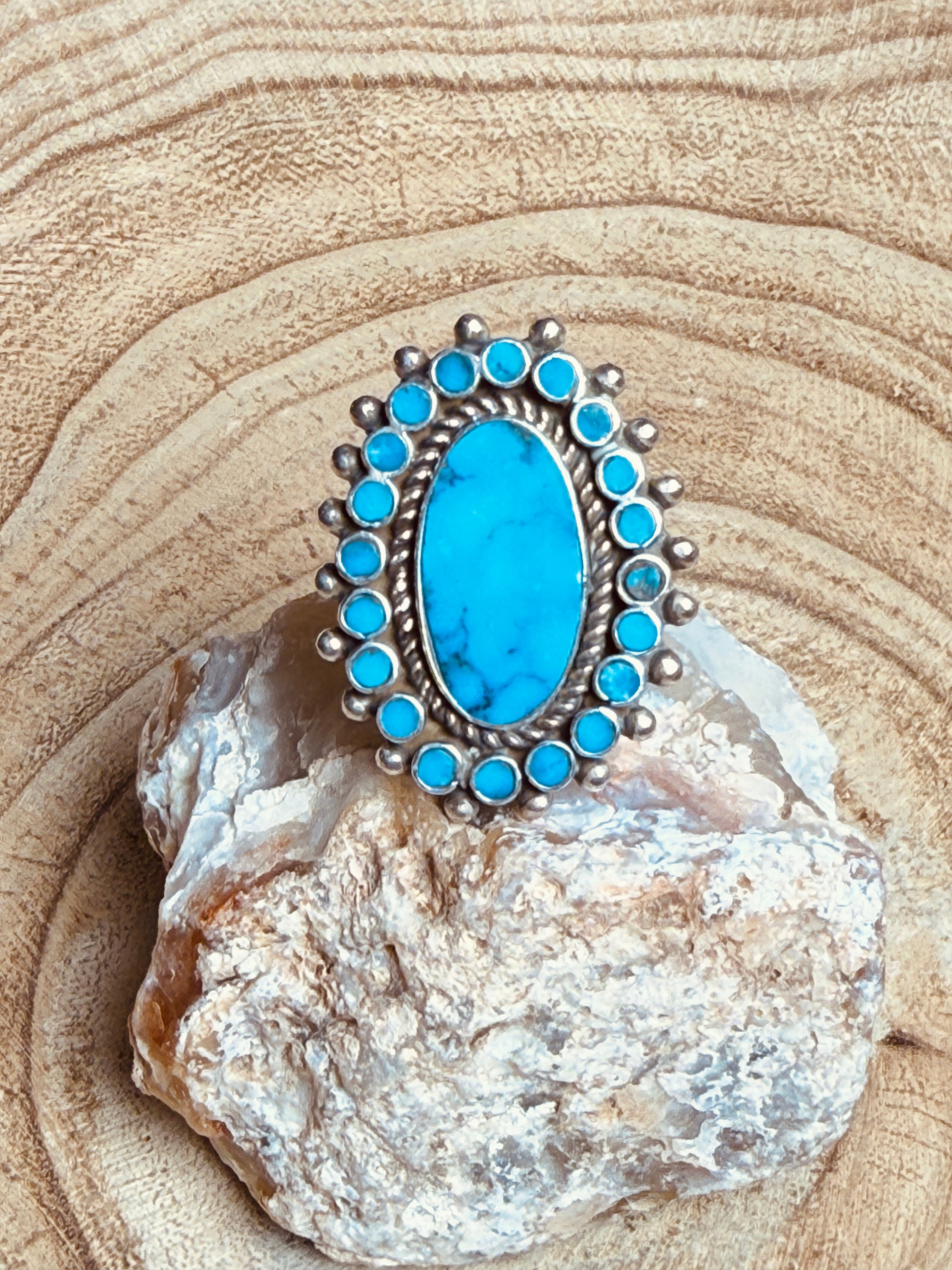 Turquoise ring with silver setting on a rock