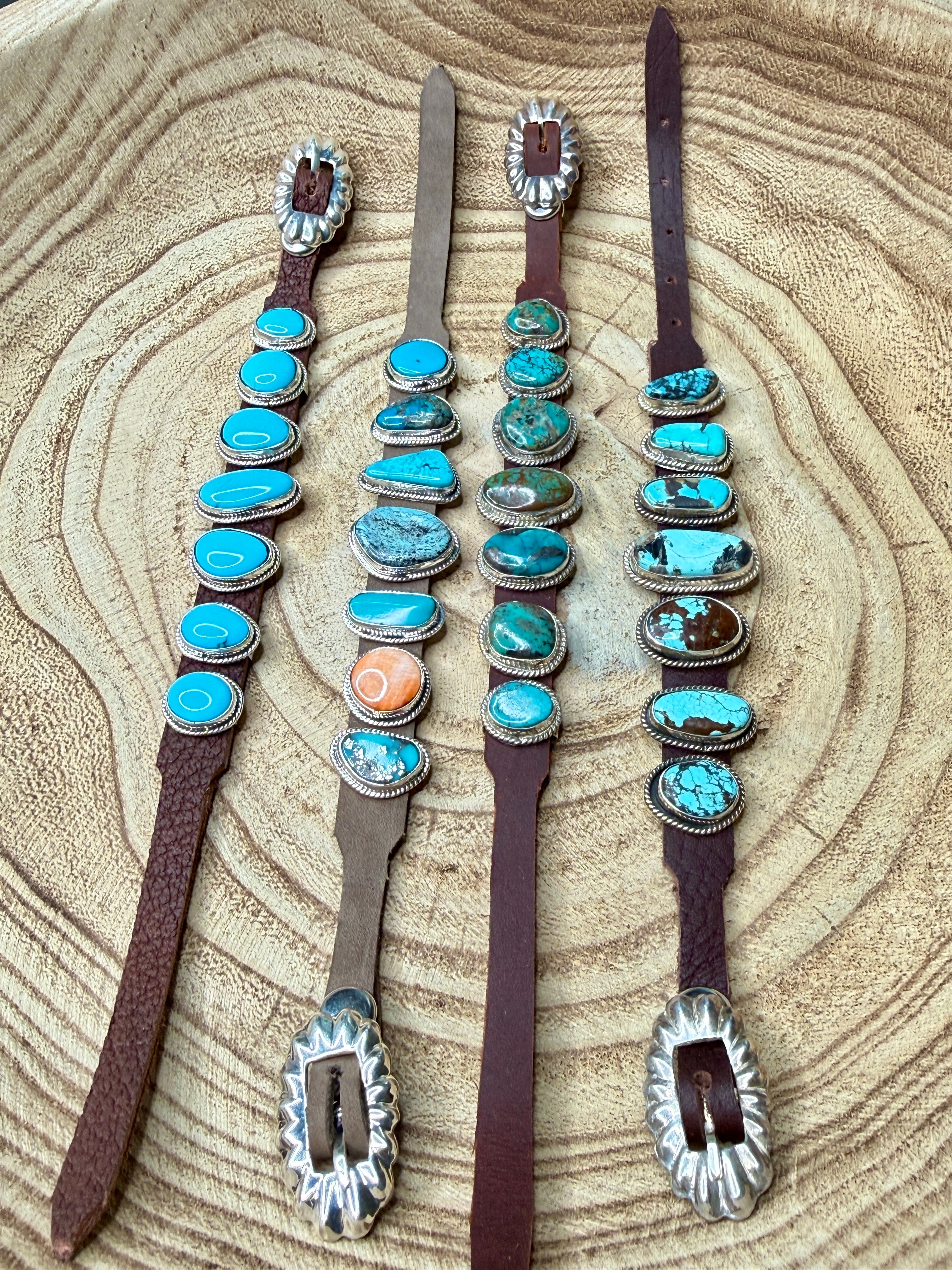 Set of decorative horse headstalls with turquoise stones on a wooden surface