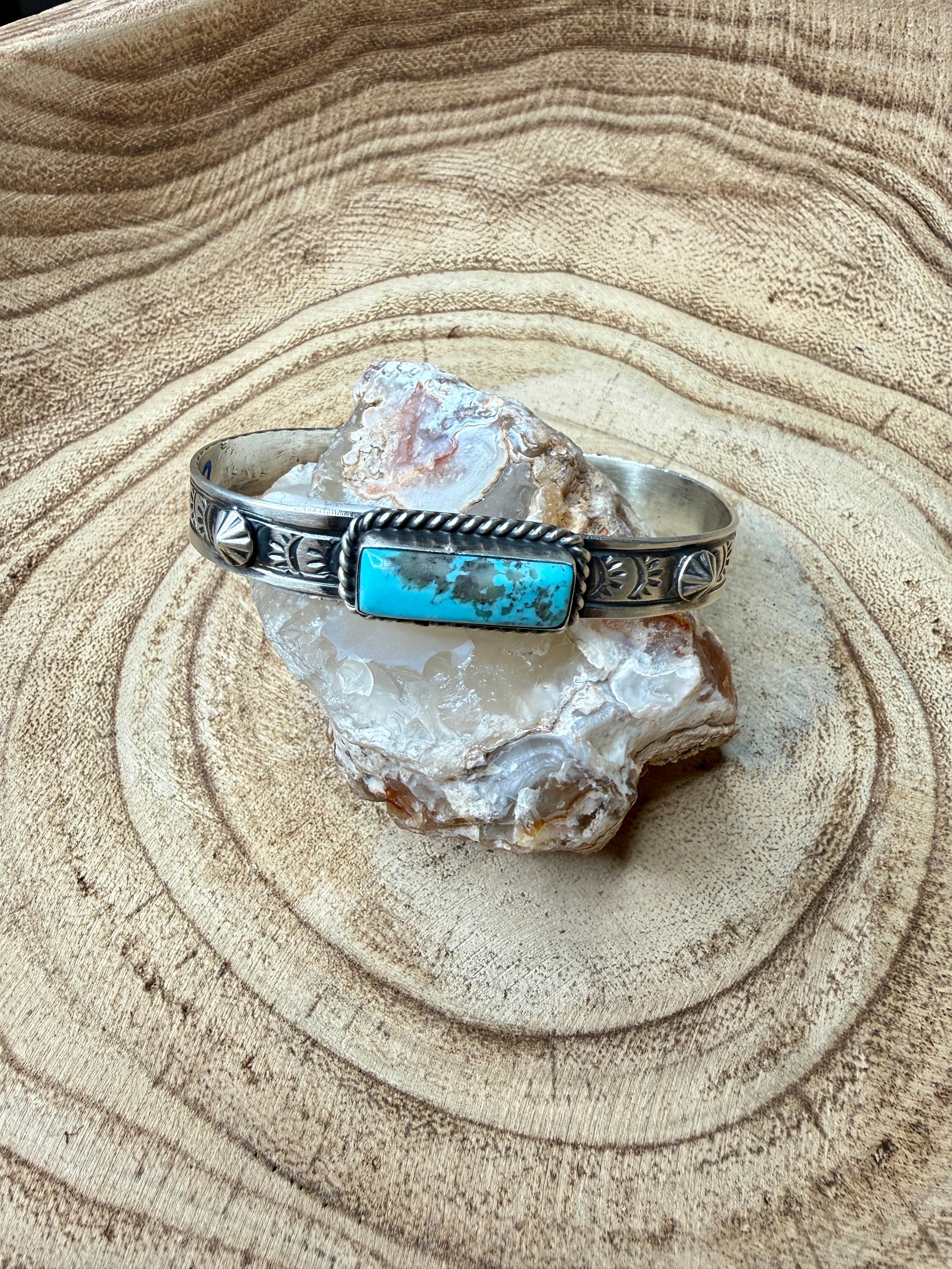 Silver bracelet with turquoise stone on a rock