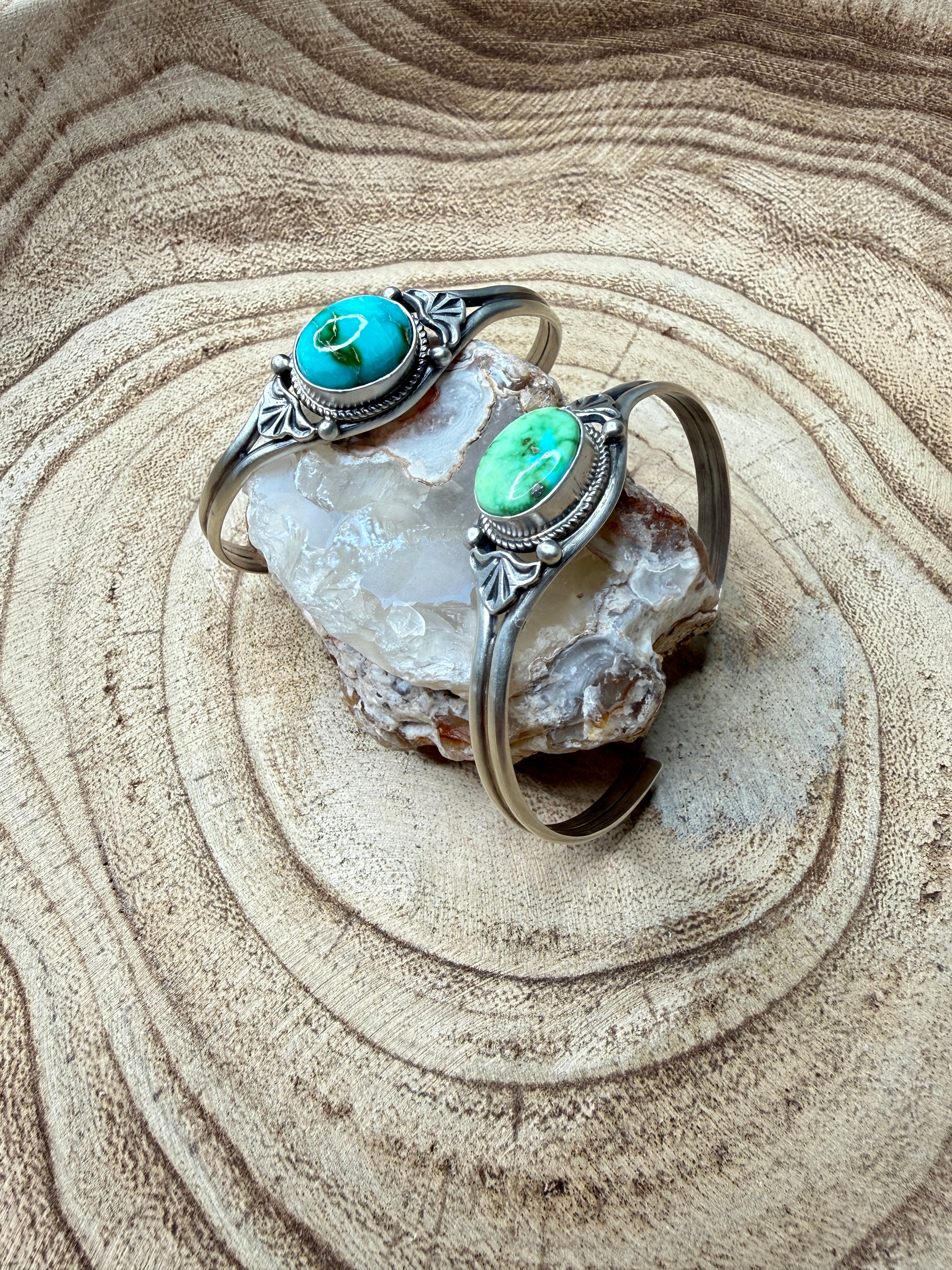 Silver ring with turquoise stones on a crystal rock in sand