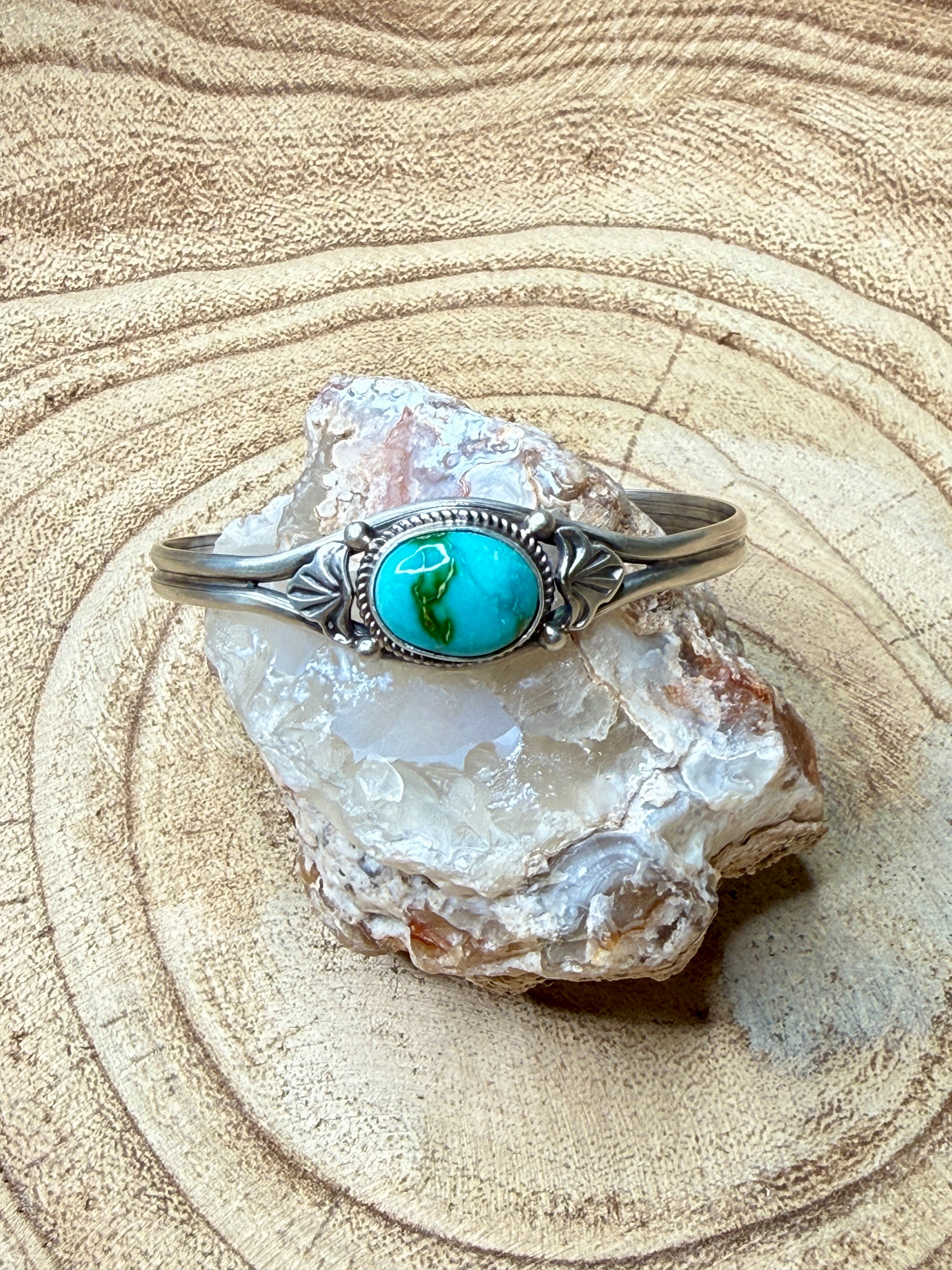 Silver bracelet with a turquoise stone on a crystal rock