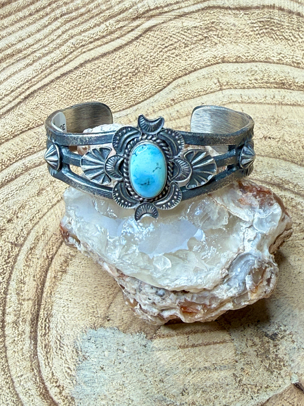 Silver bracelet with turquoise stone on a rock