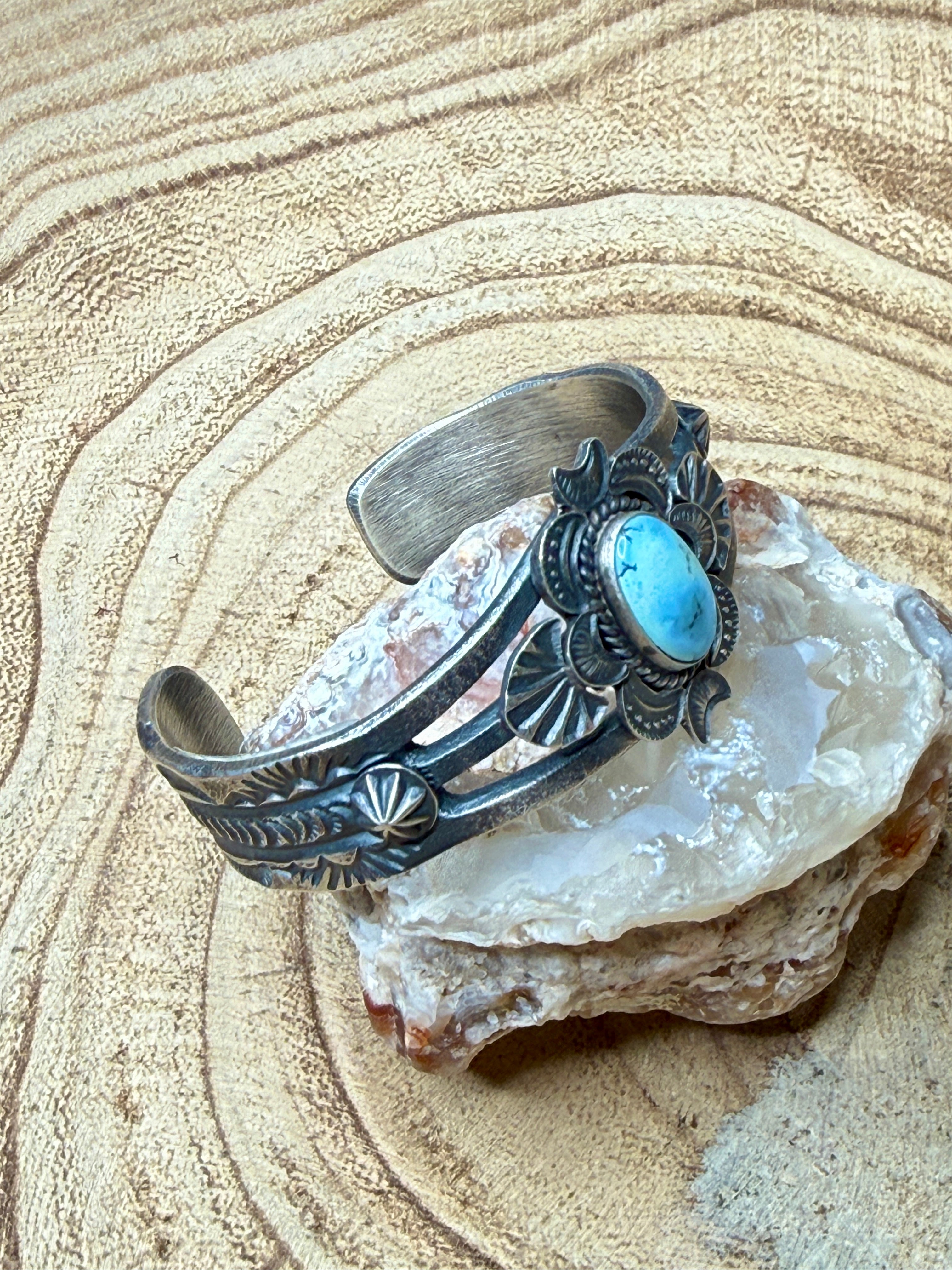 Silver bracelet with a turquoise stone on a rock