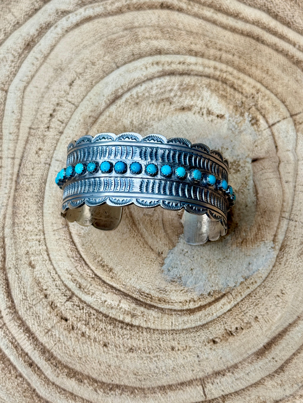 Silver bracelet with turquoise stones on a sandy background