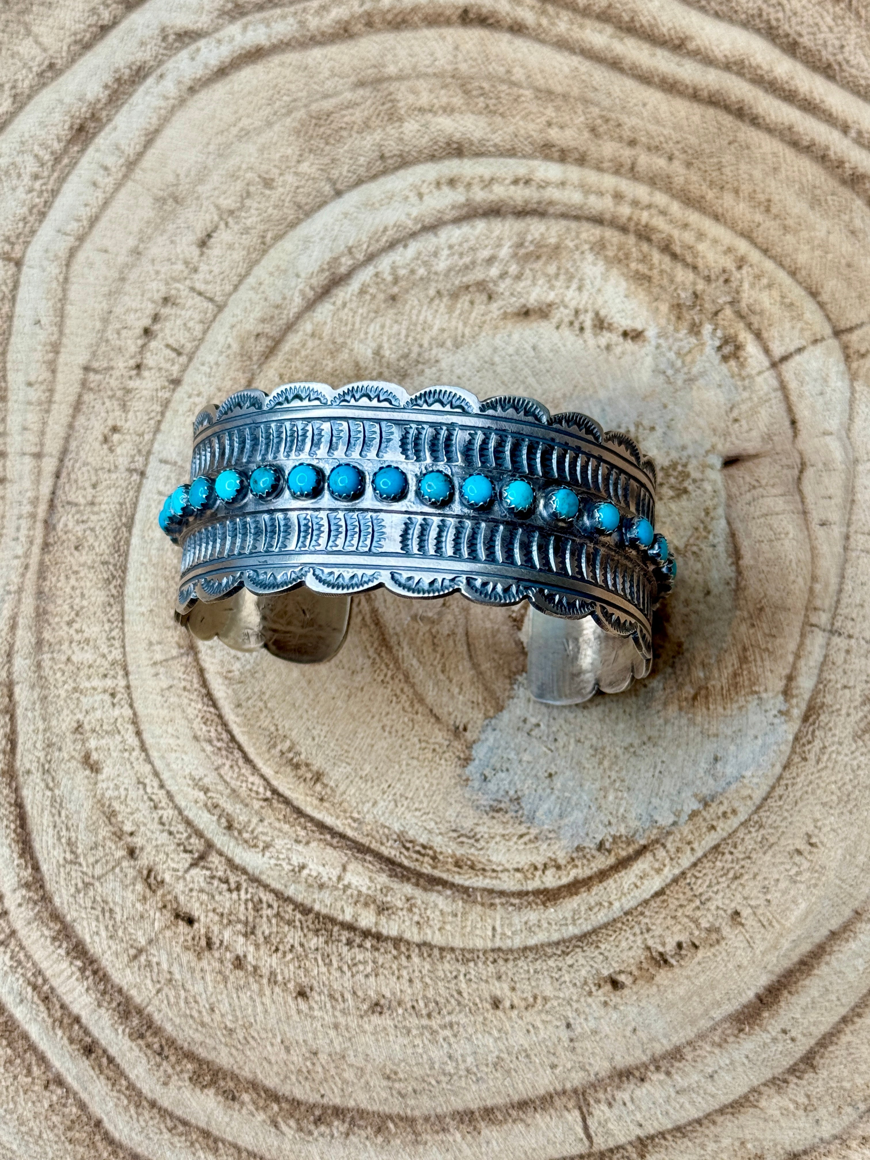 Silver bracelet with turquoise stones on a sandy background