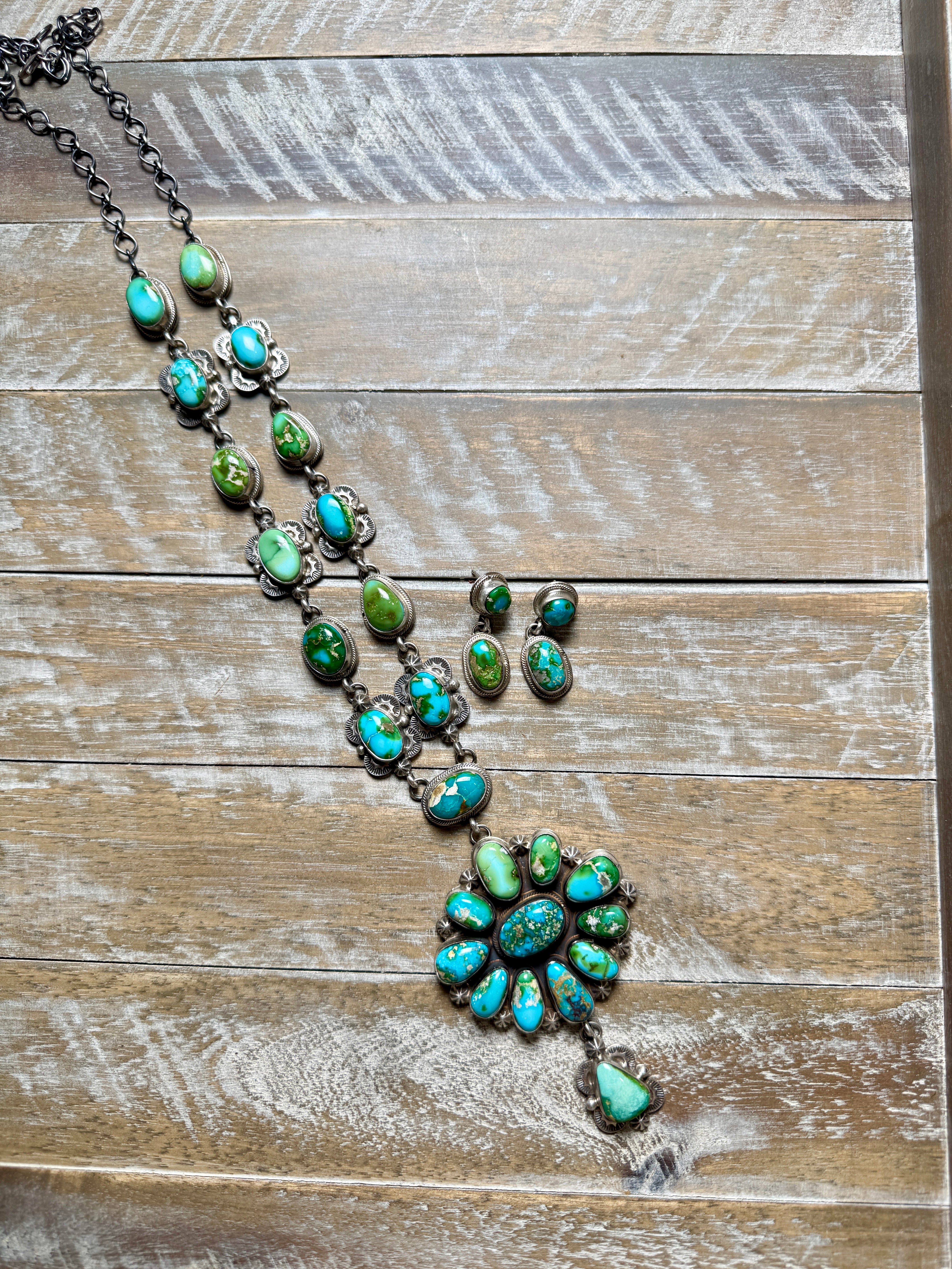 blue green stones set in silver on a wood background