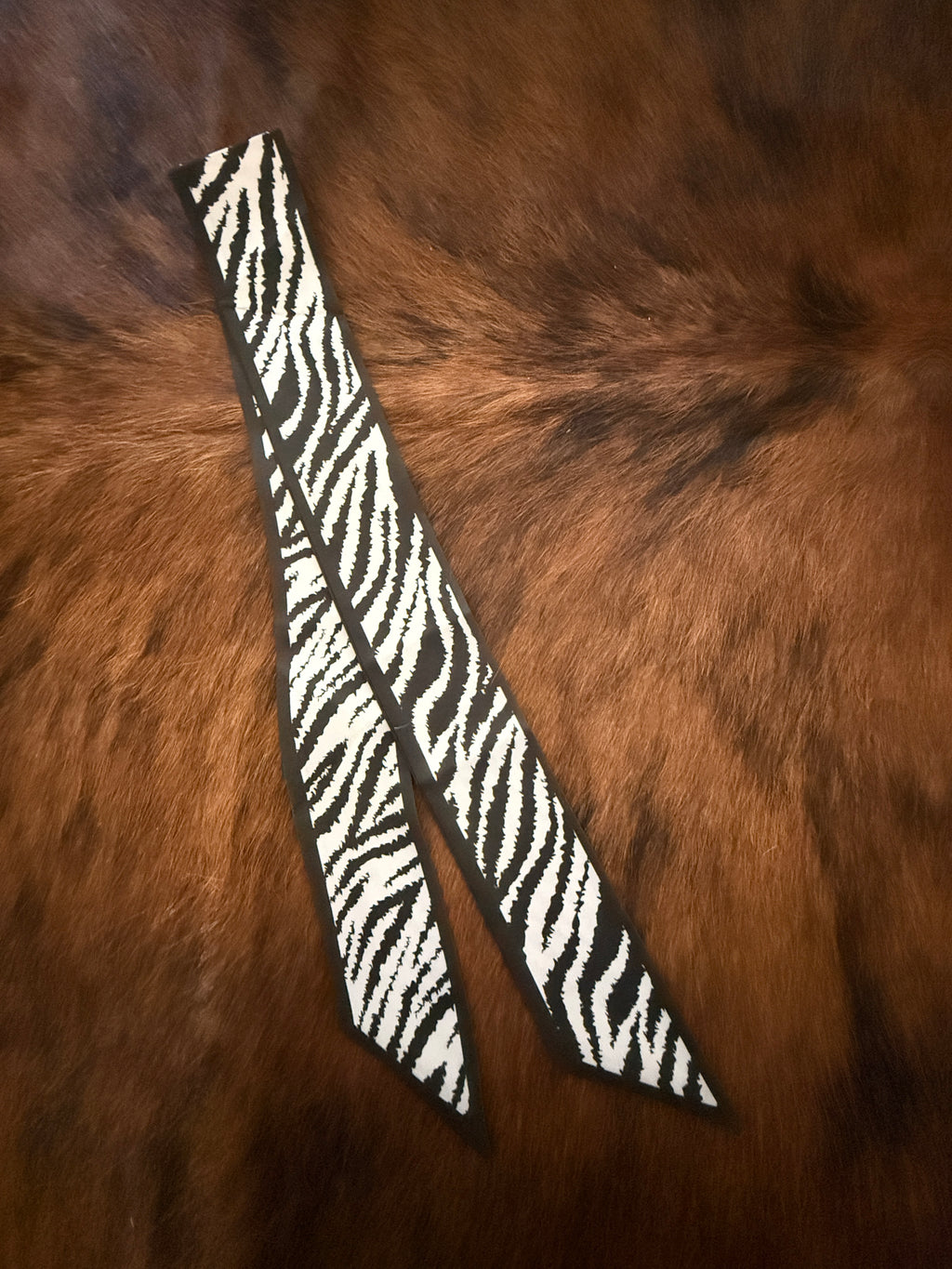 Zebra-patterned straps on a brown fur background