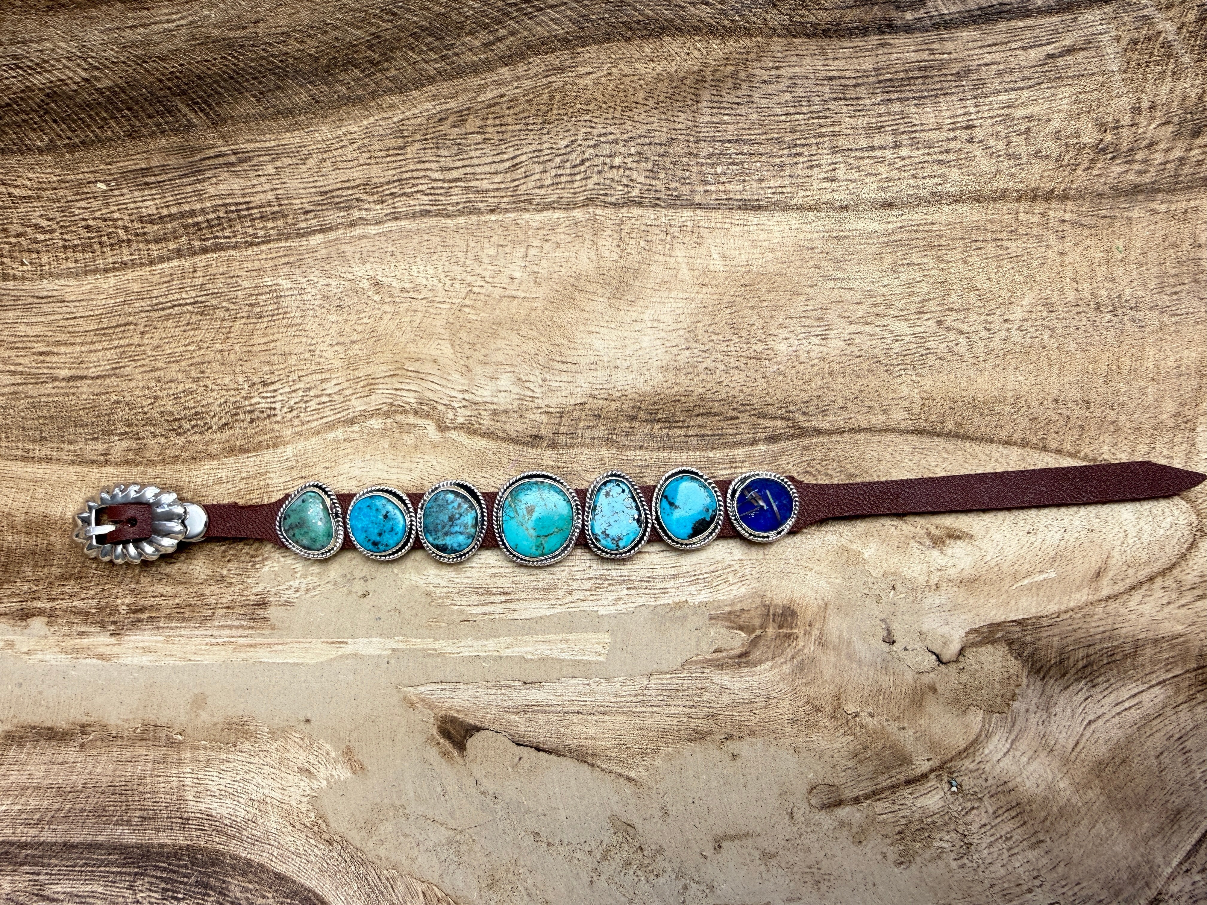 Bracelet with turquoise stones and silver accents on a wooden surface