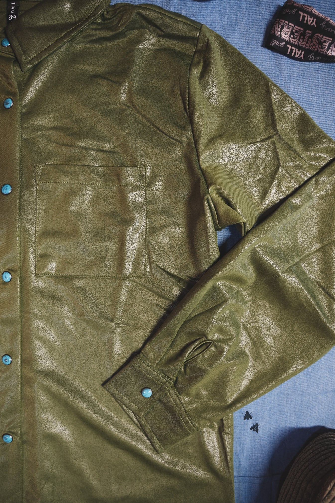 Green jacket with blue buttons on a blue surface