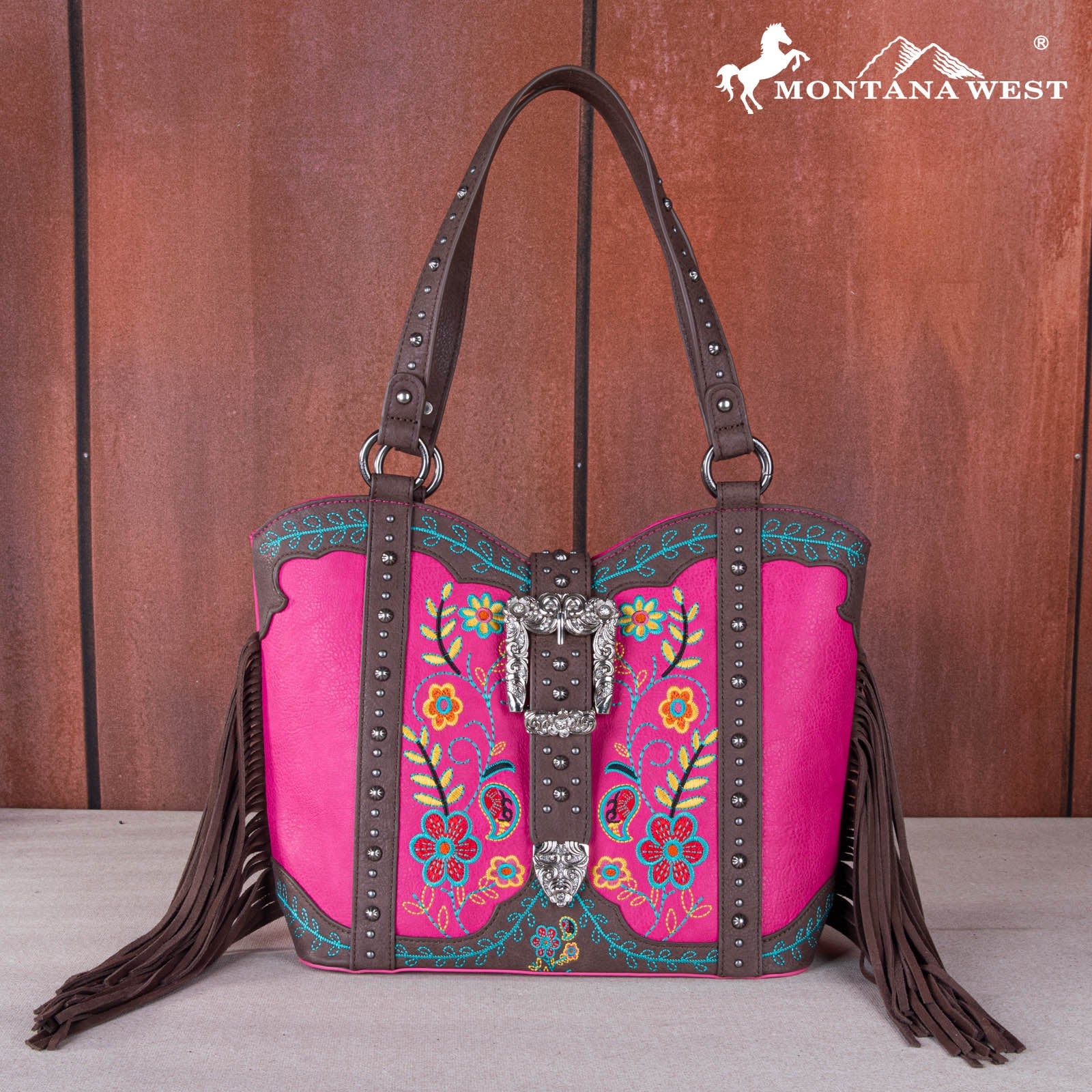 Pink handbag with floral embroidery and fringe, featuring the Montana West brand logo.