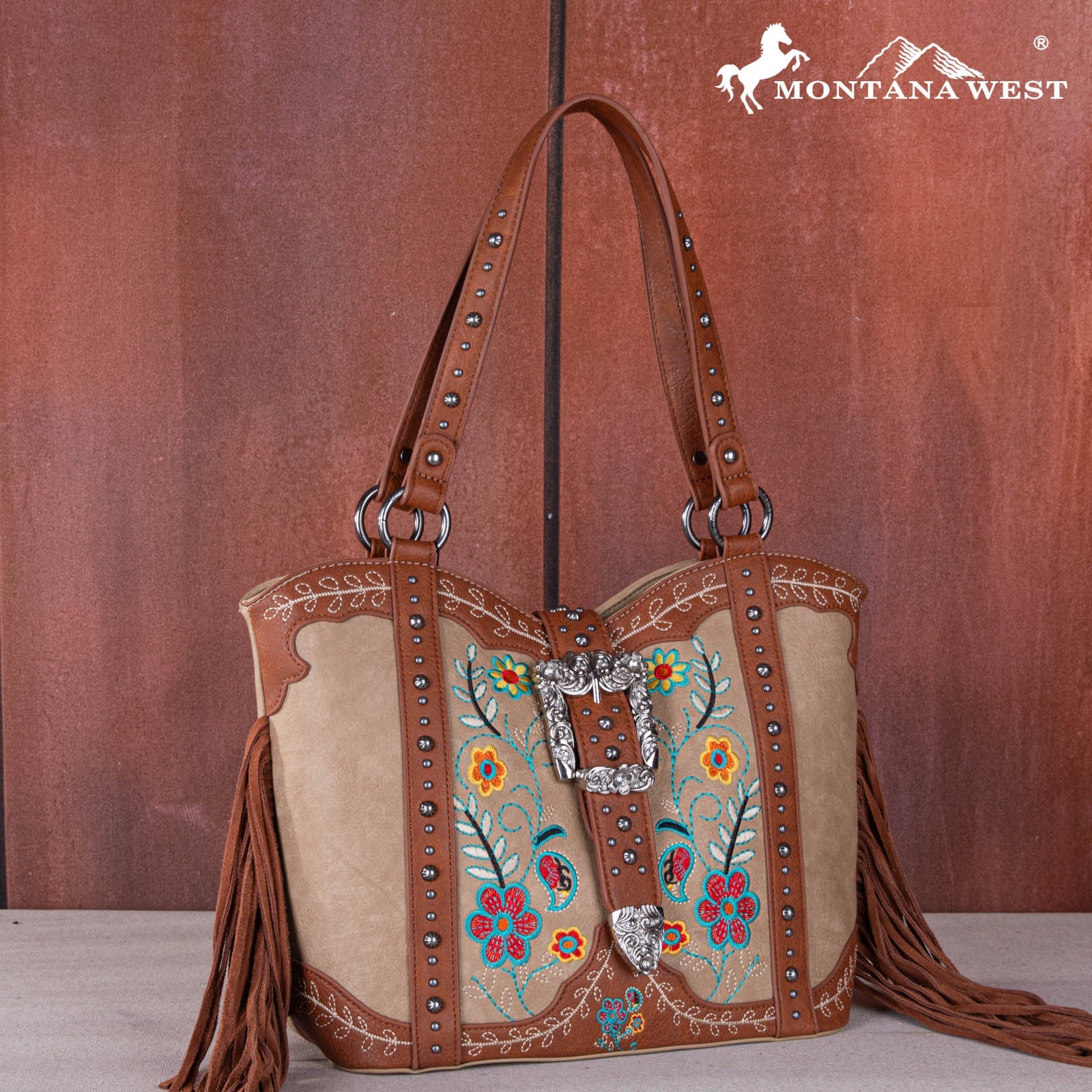 Brown leather handbag with floral embroidery and fringe, featuring the Montana West logo.