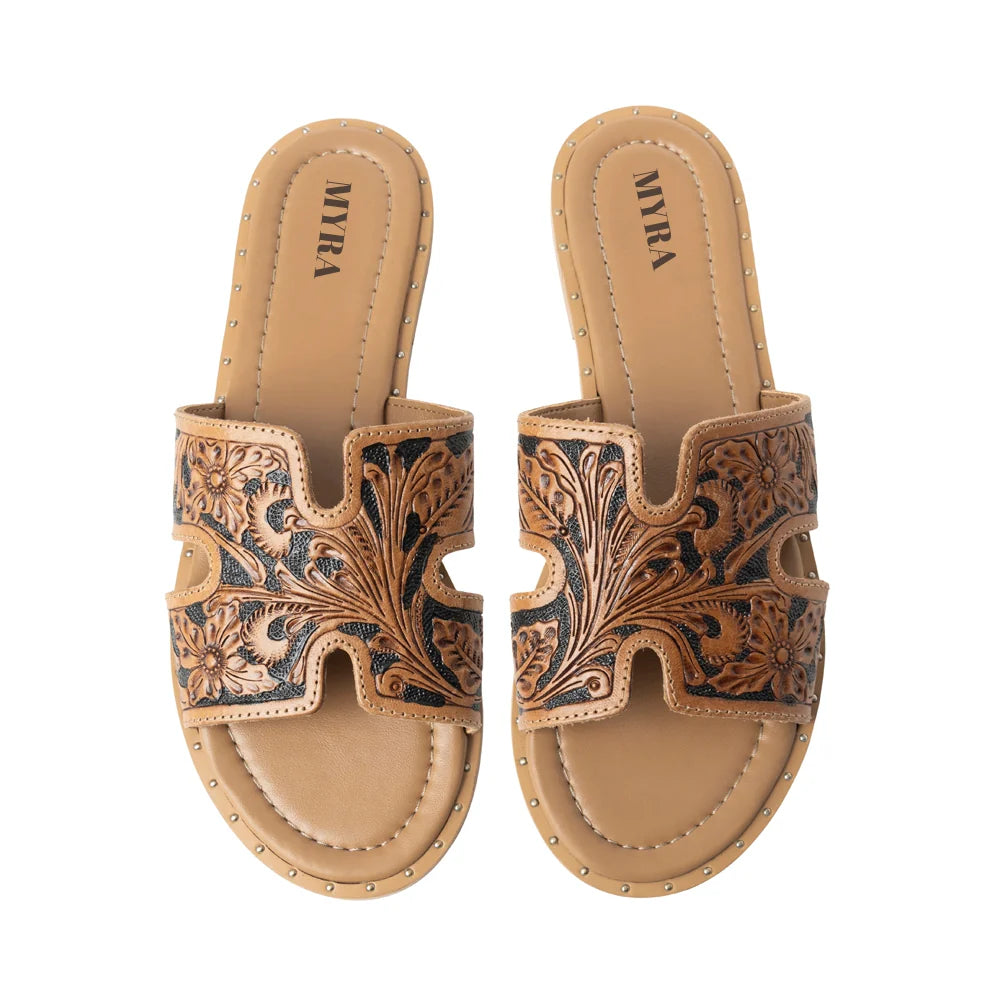 A brown leather slip-on sandal with intricate tooled floral designs and an open toe.