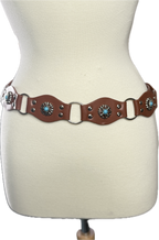 Brown leather belt with decorative elements on a mannequin.