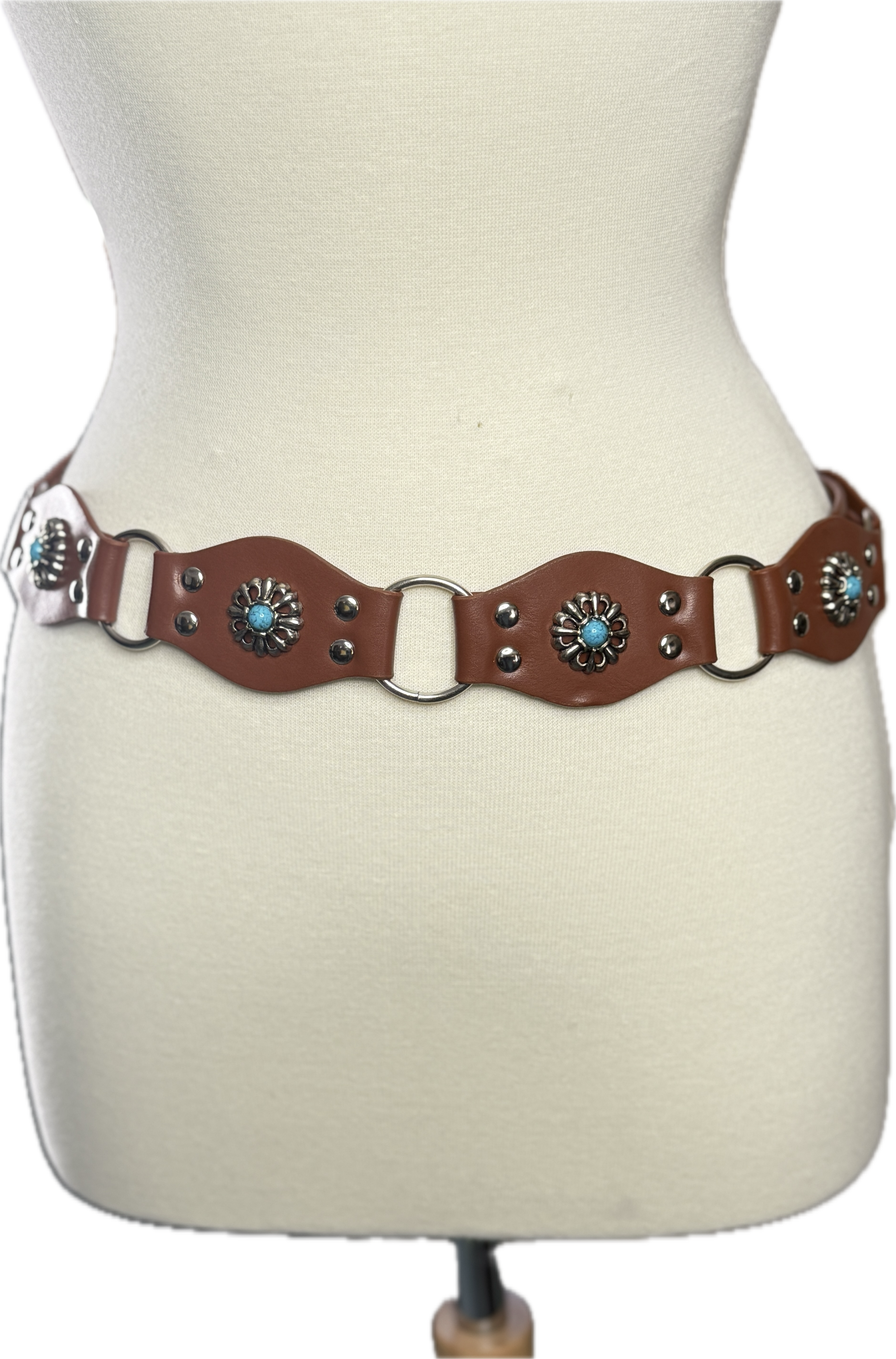 Brown leather belt with decorative elements on a mannequin.