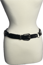 Black belt with a decorative buckle on a mannequin against a white background