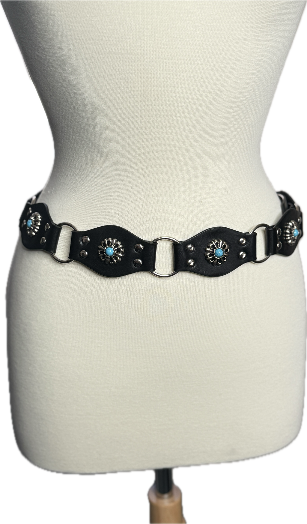 Black leather belt with decorative elements on a mannequin.