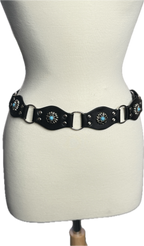 Black leather belt with decorative elements on a mannequin.