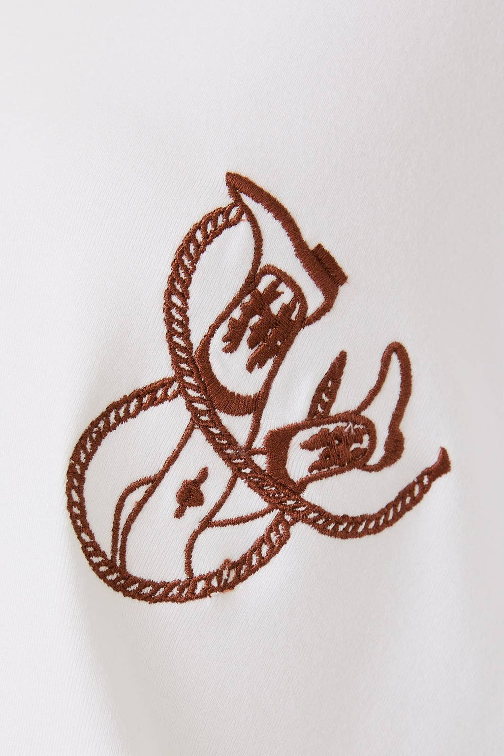 Brown embroidered design on a white fabric