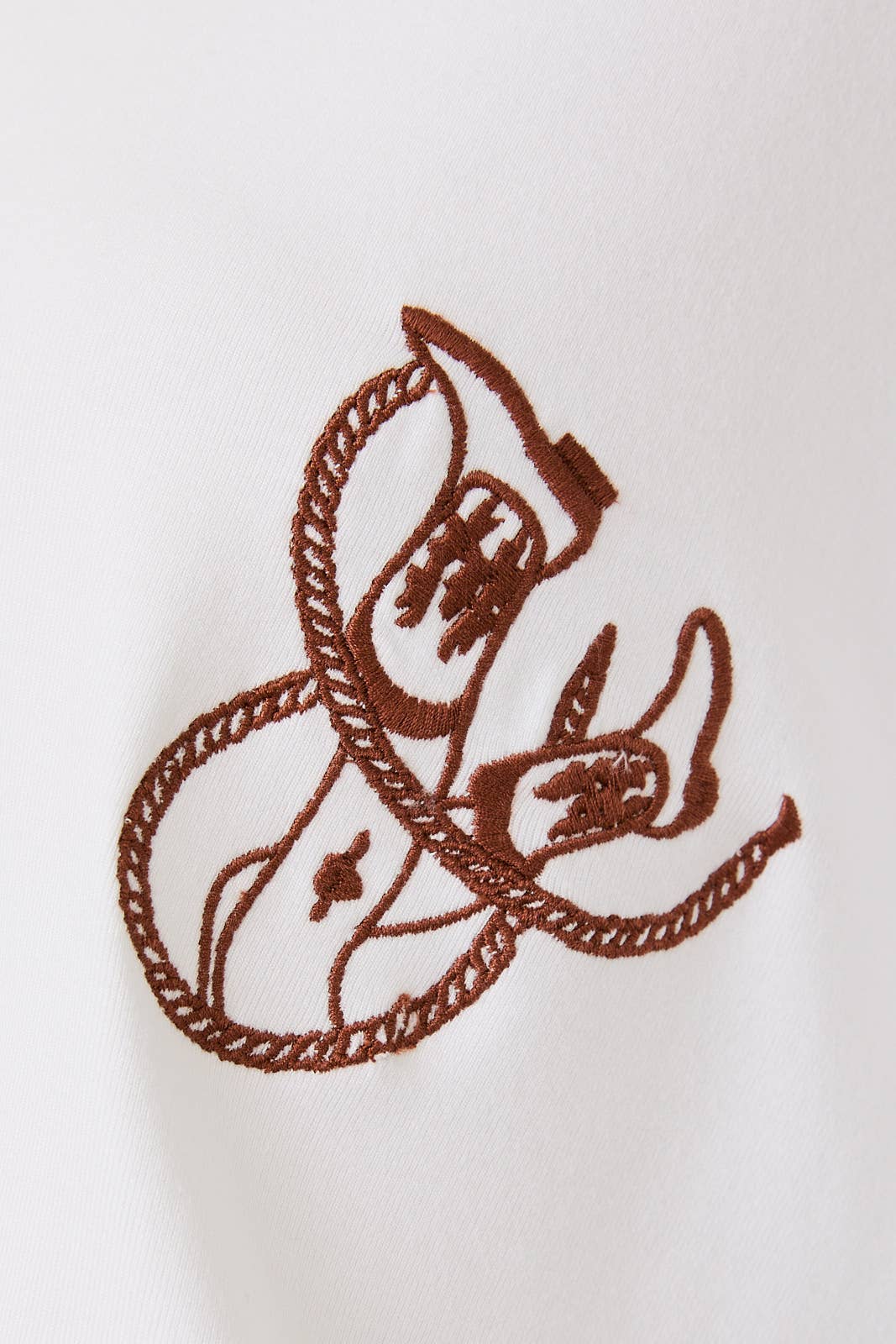 Brown embroidered design on a white fabric