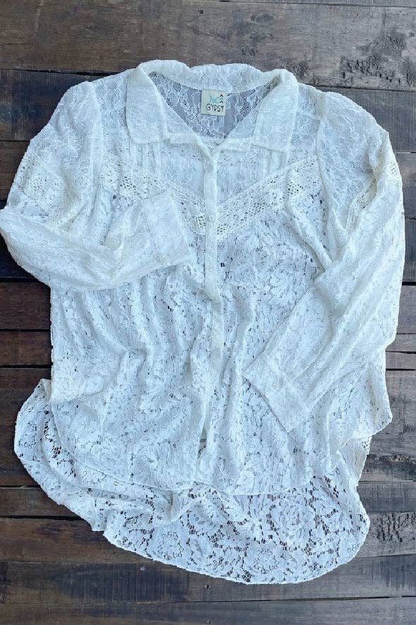 White lace cardigan on a wooden surface