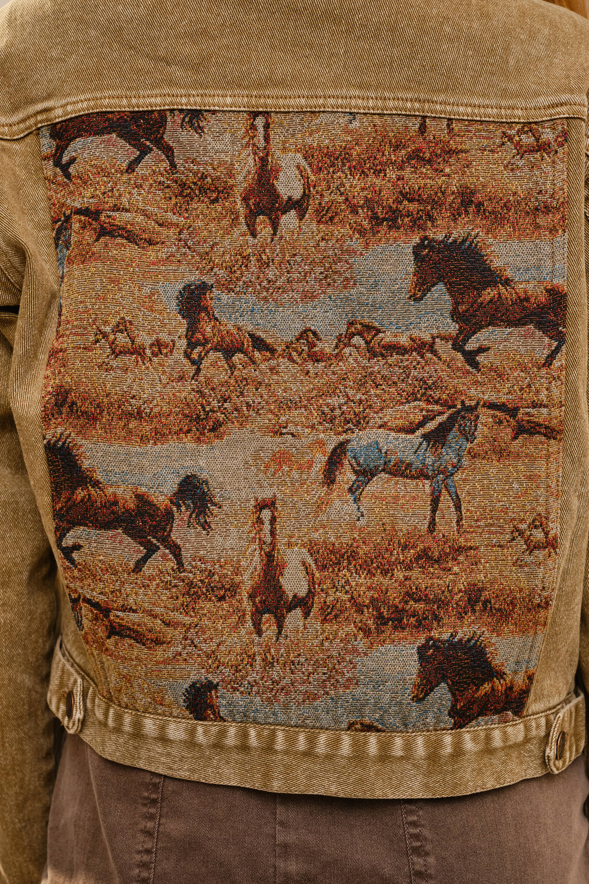 Tan jacket with a tapestry of horses on the back
