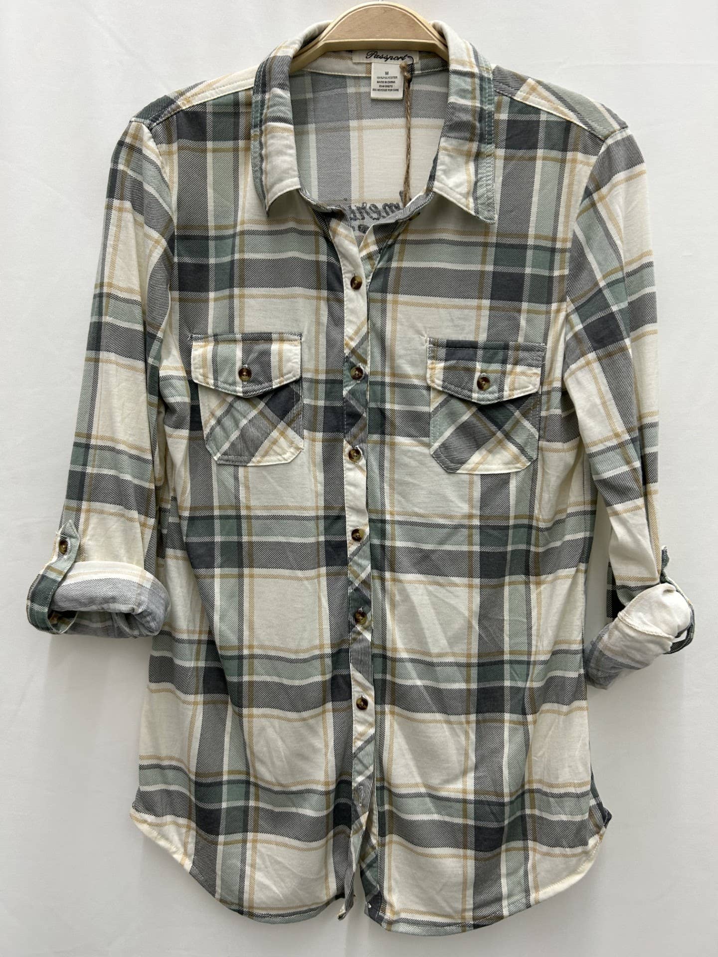 Plaid shirt on a hanger against a white background