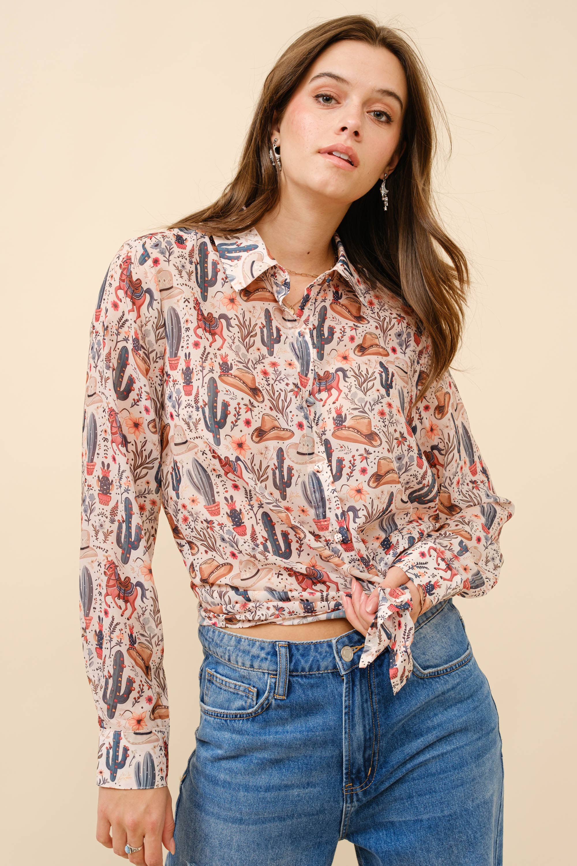 Woman wearing a patterned blouse and jeans against a beige background