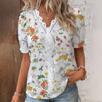 Woman wearing a floral blouse with a wooden and white brick wall background