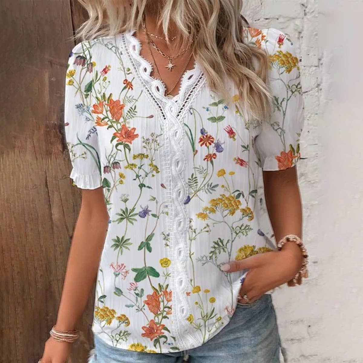 Woman wearing a floral blouse with a wooden and white brick wall background