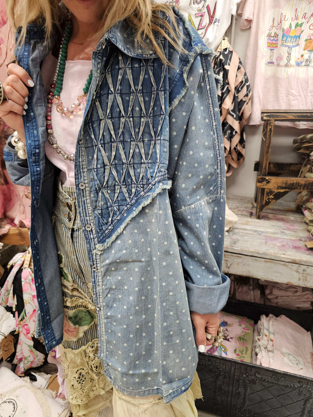Person wearing a denim jacket with geometric patterns in a store setting