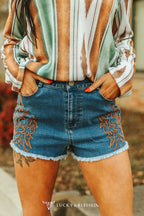Denim shorts with boot stitching and frayed hem on a woman's body